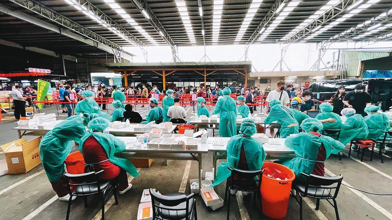 公衛專家指出，控制小群聚感染擴大成社區流行，關鍵仍在篩檢。圖為北市環南市場篩檢畫面。
