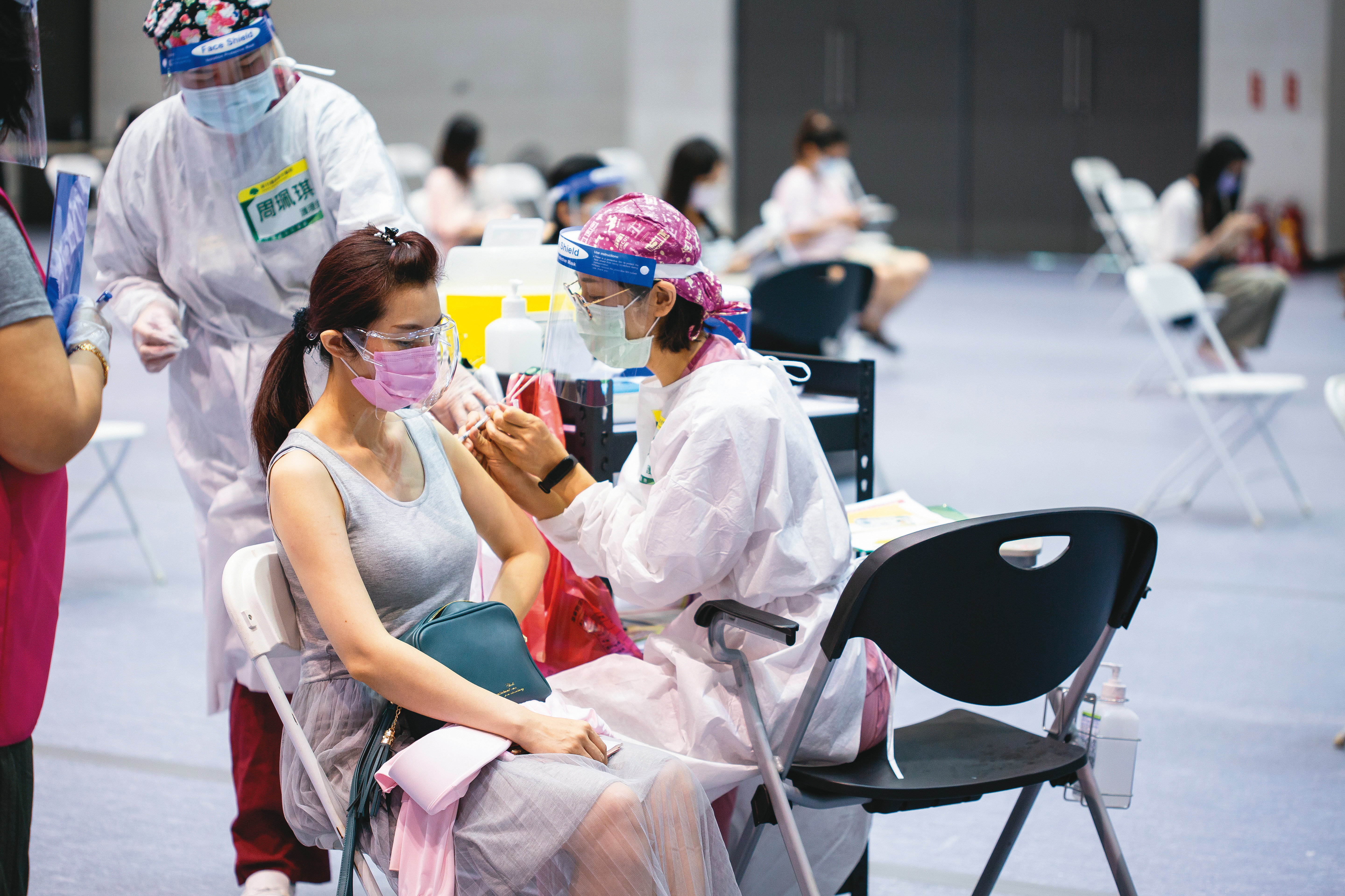 台大公衛學院模擬數據，若每天可接種疫苗15萬人，即便降至2.5級警戒，每天確診數仍可壓制在30人以下。圖為民眾施打疫苗畫面。