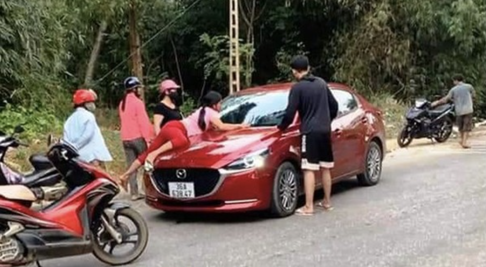 越南一名人妻發現丈夫偷吃,竟趴在引擎蓋上阻止老公。(翻攝自 CLIP TAINAN GIAOTHONG. VIETNAM TRAFFIC CLIP YouTube)