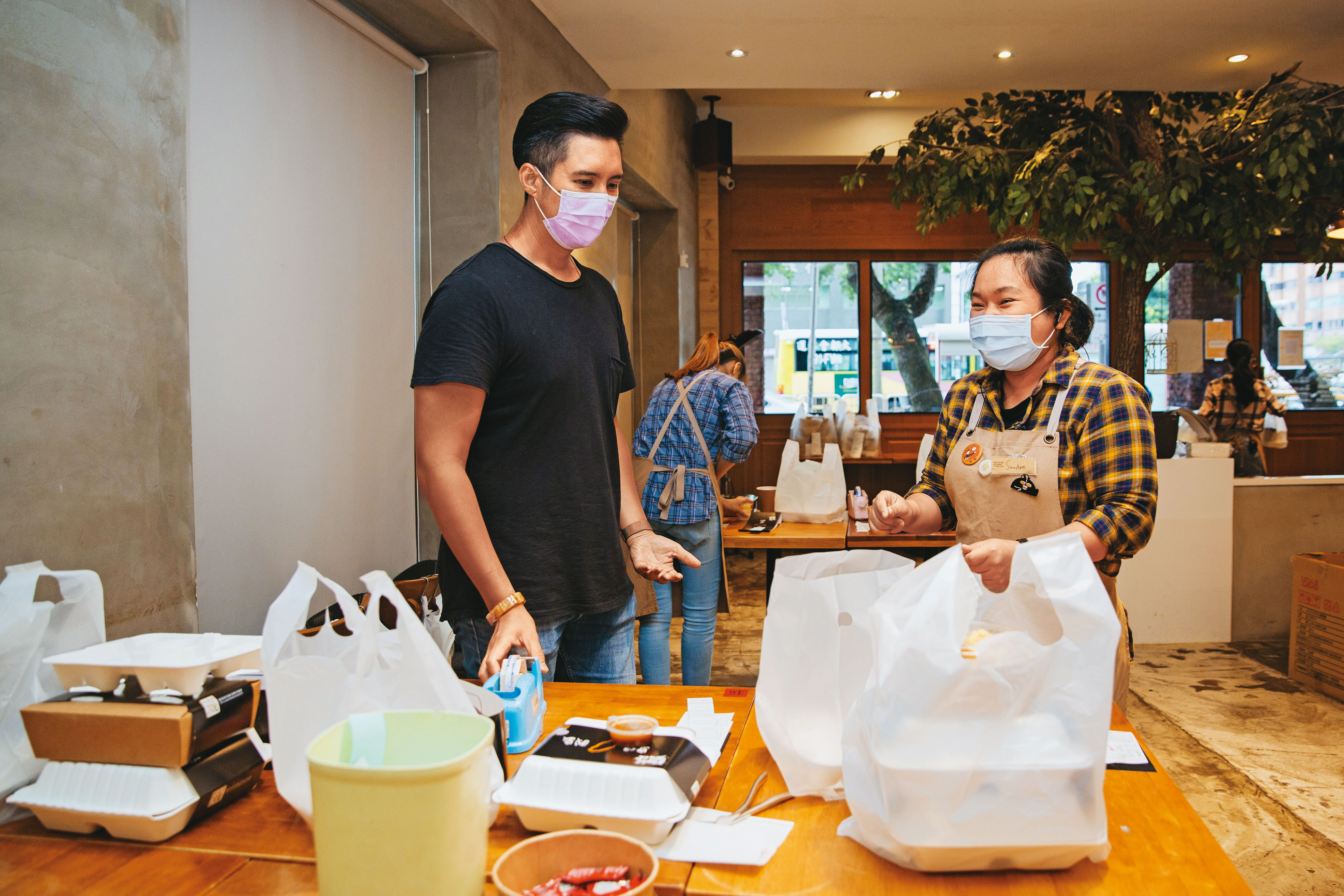 疫情海嘯來得又急又快，黃寶世（左）將一樓用餐區改為臨時的備餐流水線。