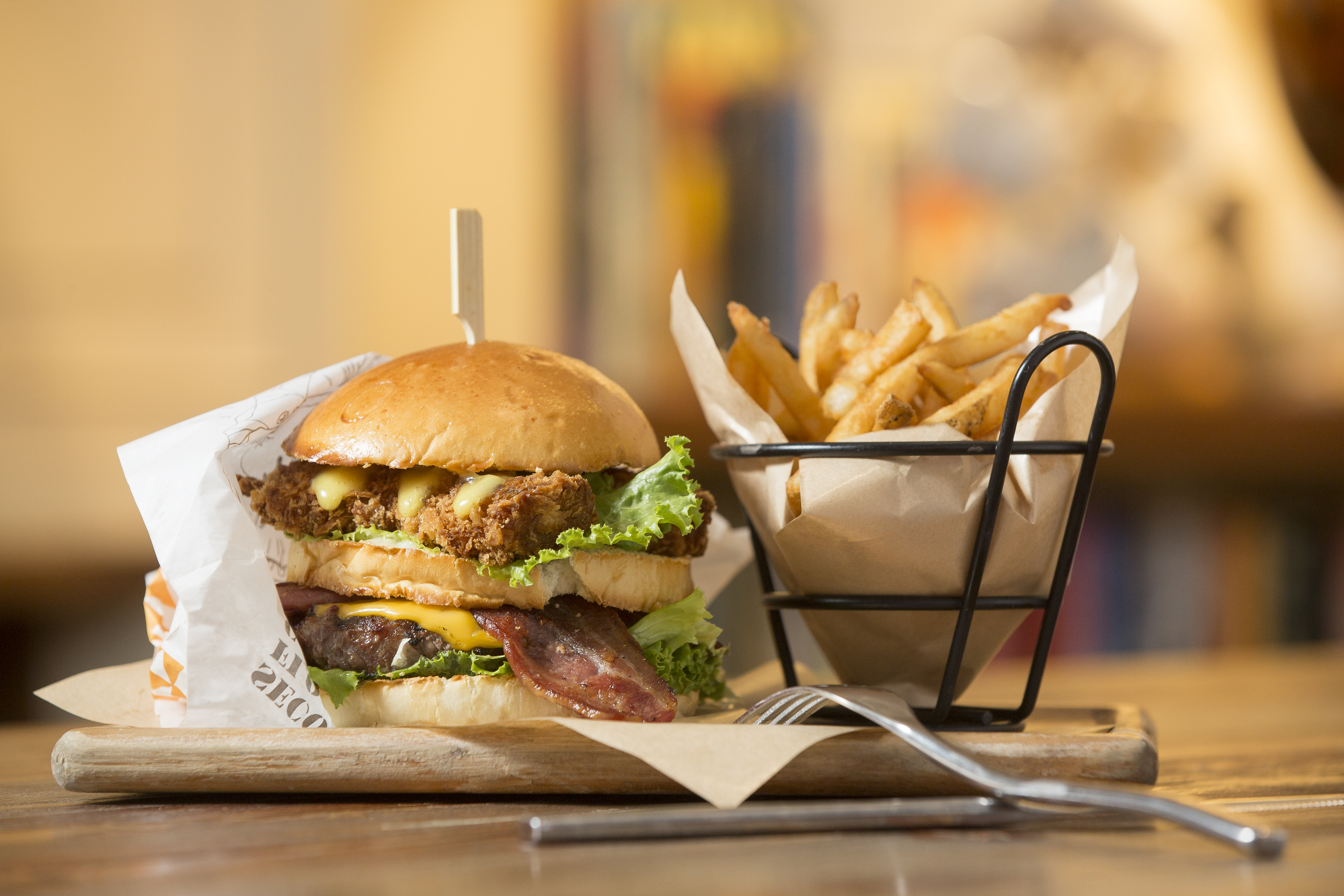 黃寶世從國外取經，再結合台灣飲食習慣變化，不斷推陳出新。圖為加了牛肉、培根及炸巴沙魚的招牌雙層漢堡巴士。（390元／份）