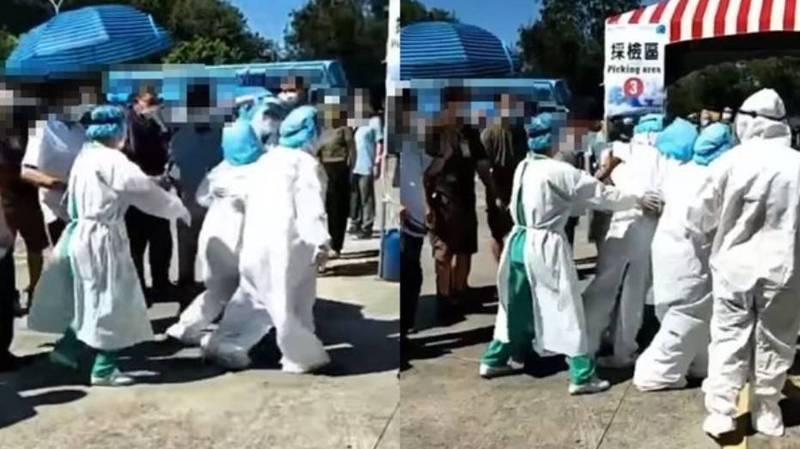 一名醫護人員疑似中暑，直接在篩檢站癱軟在地。（翻攝自爆料公社）