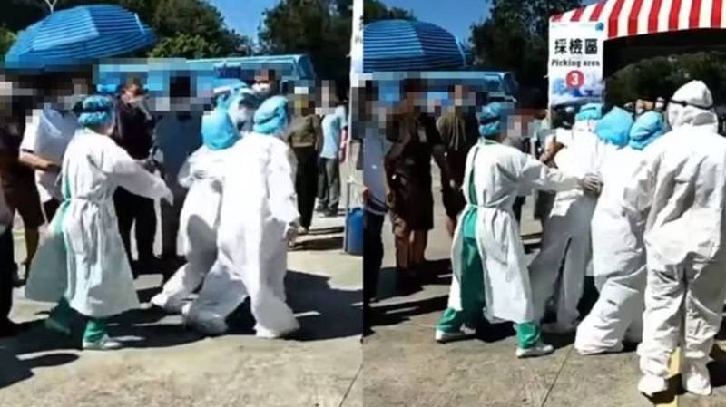 一名醫護人員疑似中暑，直接在篩檢站癱軟在地。（翻攝自爆料公社）