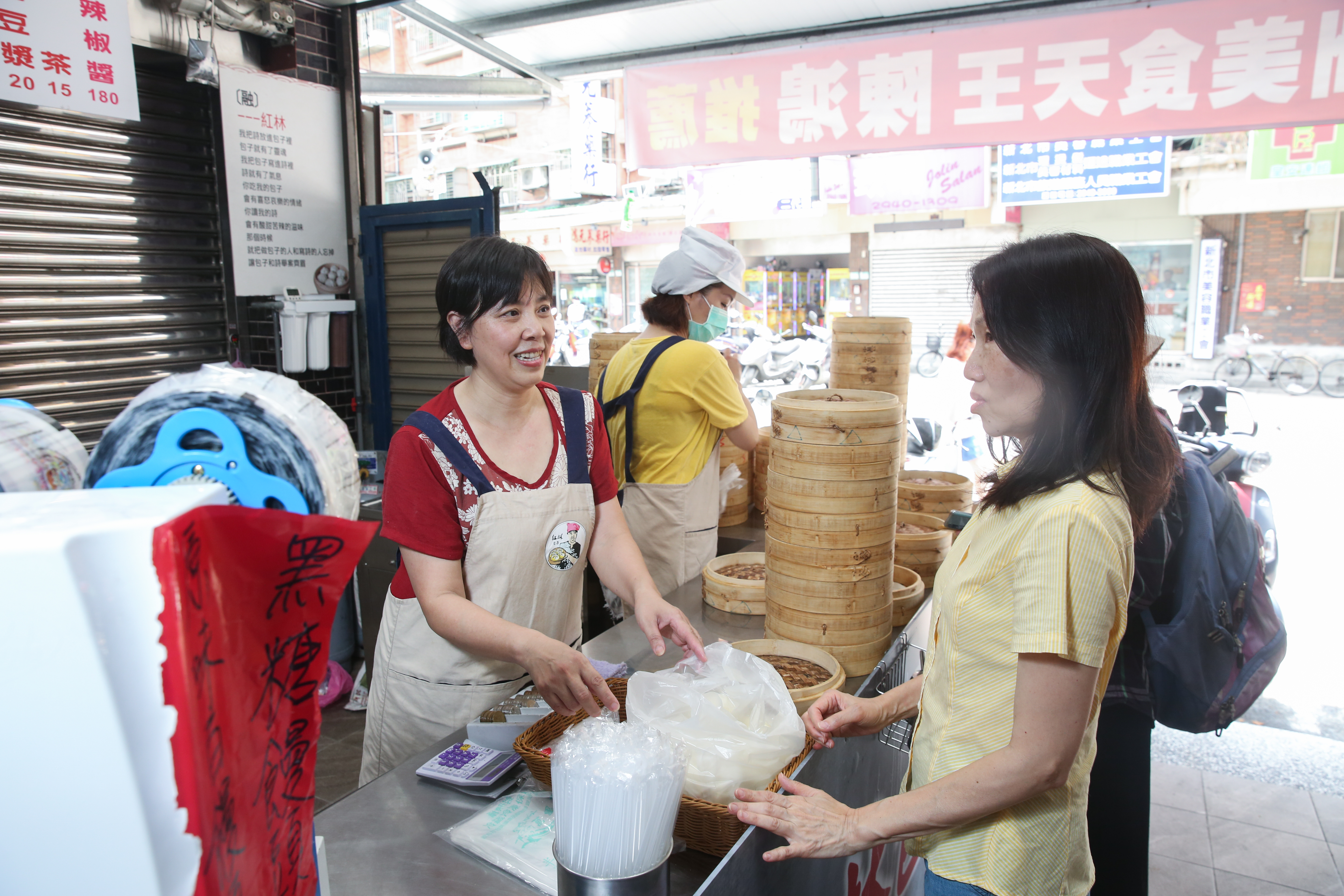 陸配王紅林（紅衣）靠著自己的努力在台灣闖出一片天，她的老麵包子擄獲一票鐵粉客人支持。（疫情爆發前拍攝）