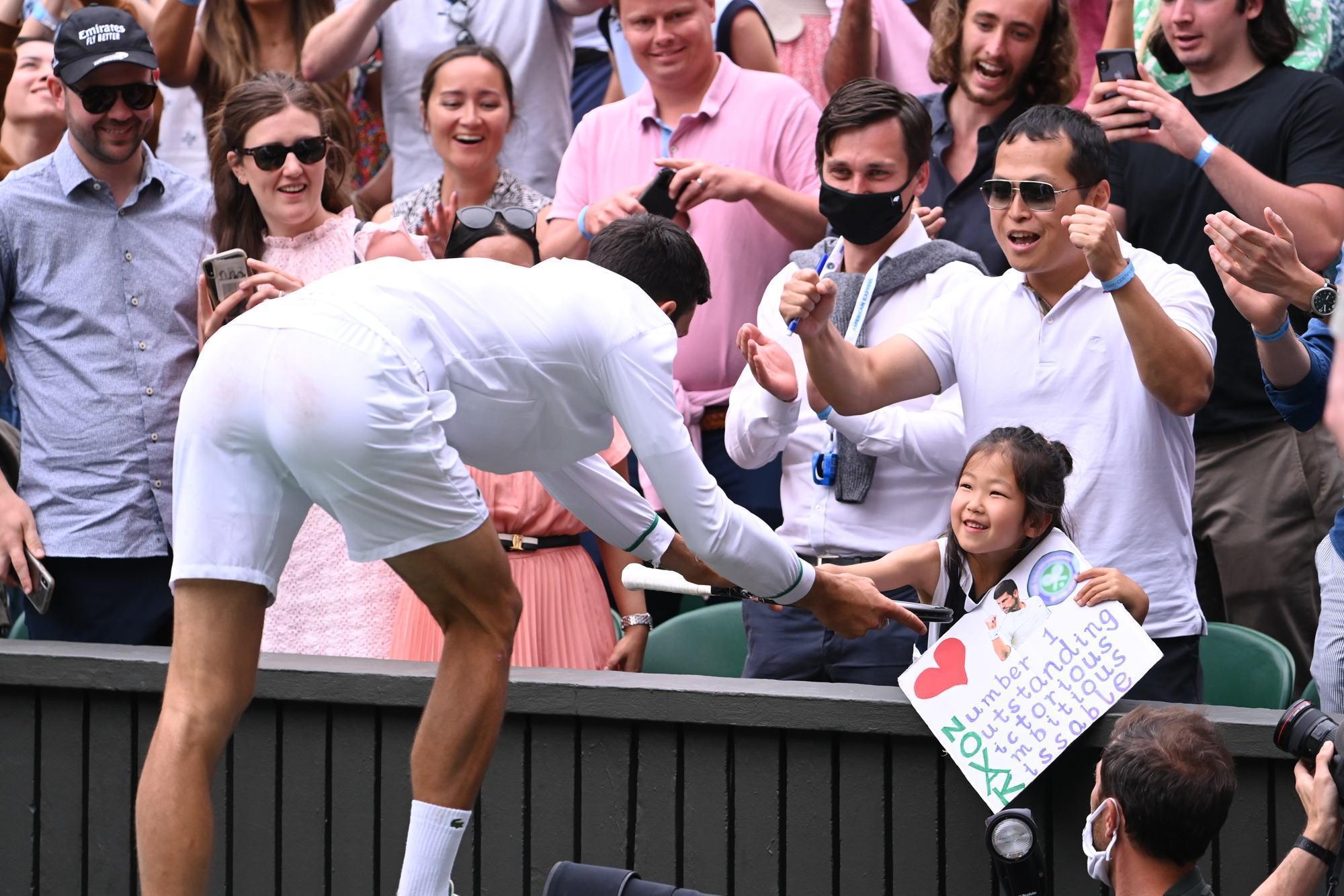 喬科維奇奪冠後,雙手捧著奪冠球拍,送給場邊一名小妹妹。(翻攝Wimbledon推特)