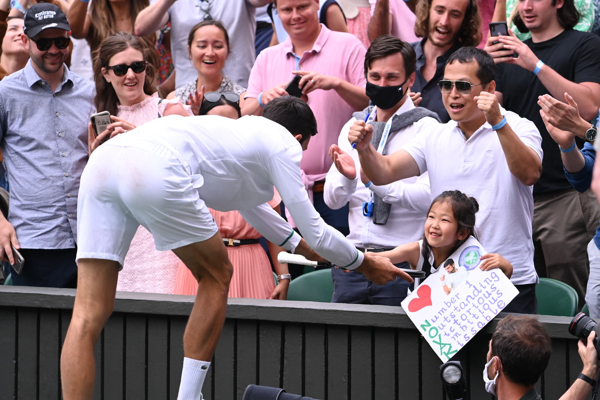 喬科維奇奪冠後，雙手捧著奪冠球拍，送給場邊一名小妹妹。（翻攝Wimbledon推特）