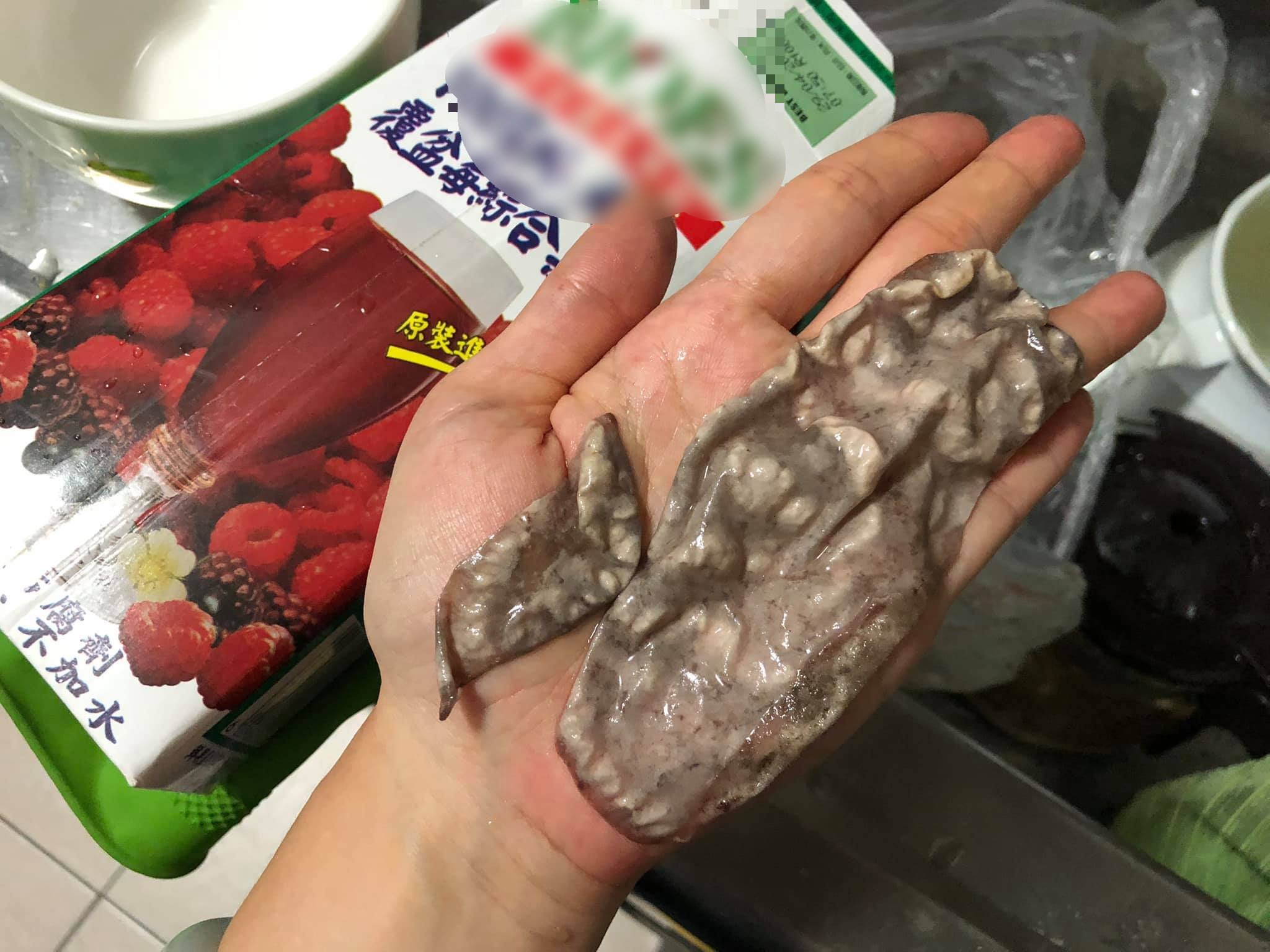 果汁盒中謎樣的沉澱物在手掌上攤開後,面積非常驚人。(翻攝爆料公社臉書)