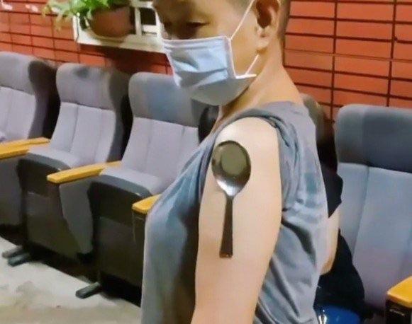 賴銘偉的媽媽在打完莫德納疫苗後,拍影片顯示手臂能吸住湯匙。(翻攝自臉書)