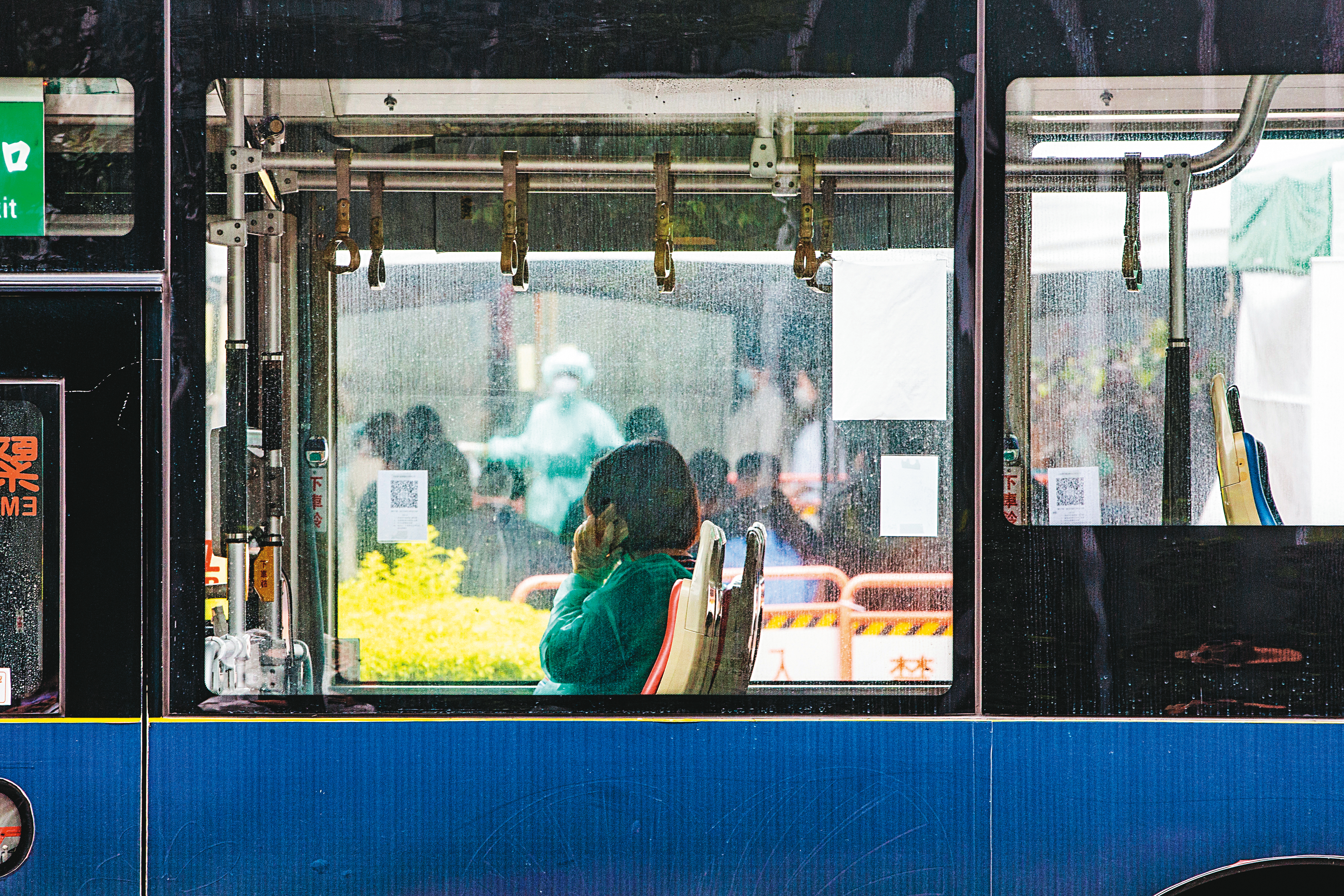 有些新冠感染者至今仍有後遺症，無法恢復正常生活。圖為一名採檢陽性民眾搭上防疫公車準備隔離，連忙打電話通知親友。