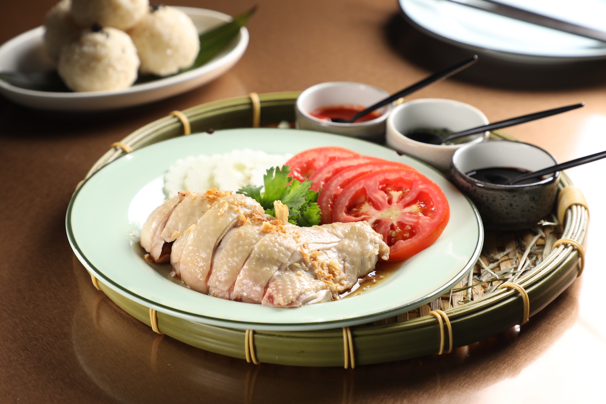 「海南雞飯」搭配黑醬油、薑蔥、辣椒三種醬料，要壓扁飯球一起吃。（480元／份）