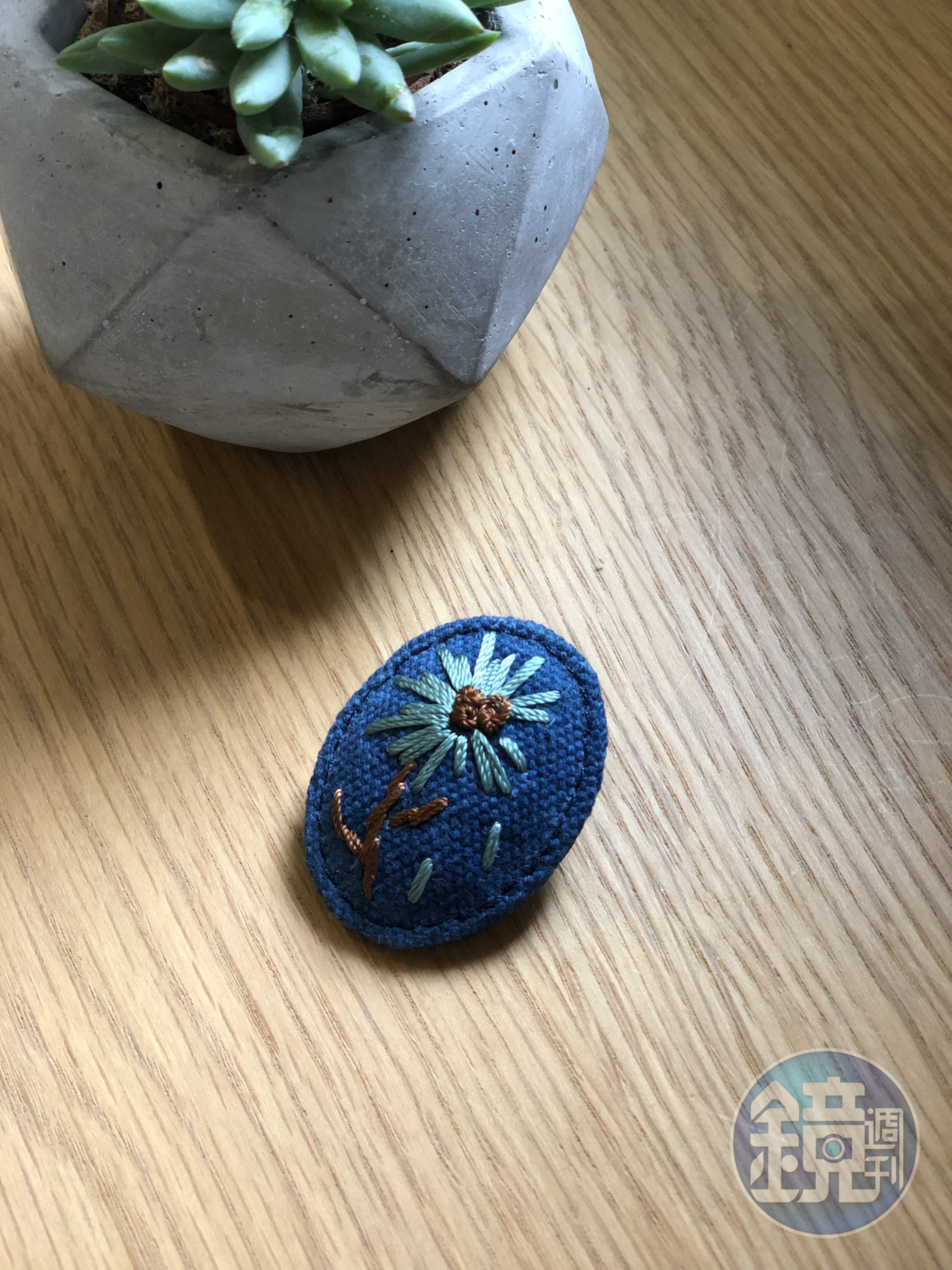以寥寥幾針點出花草模樣的胸針，別在衣領上頗收畫龍點睛之效。