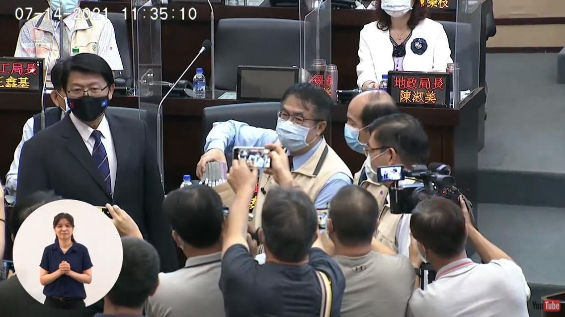 黃偉哲（右）代表台南市政府，收下謝龍介（左）捐贈的100萬元。（翻攝自台南市議會YouTube）
