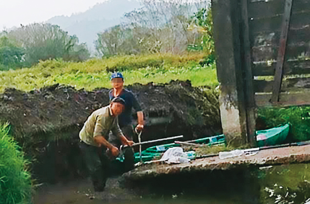 黃順昱疑似雇工偷挖堤岸，破壞古蹟水門和便橋，被村民逮個正著。（讀者提供）