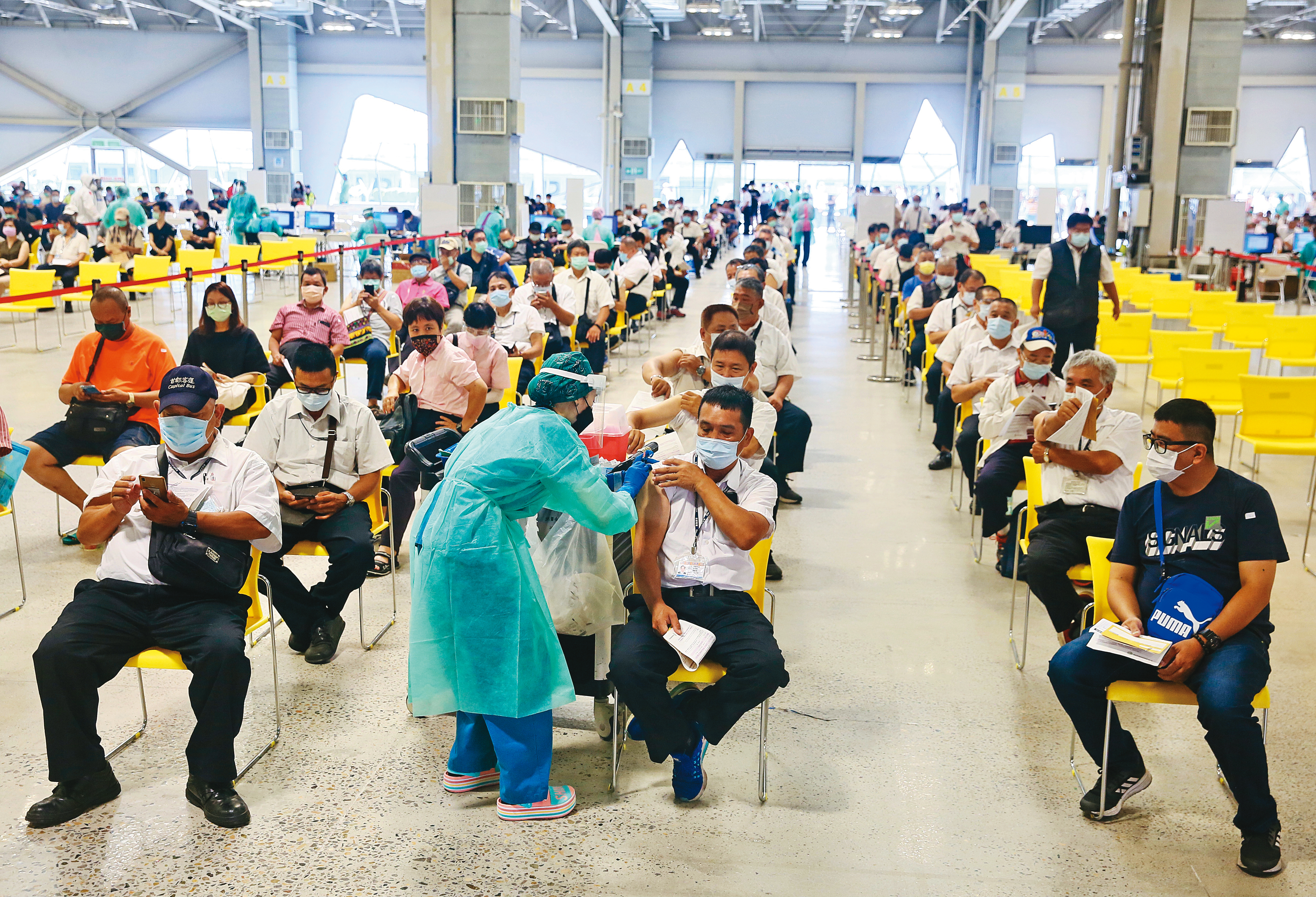 力拚群體免疫，大批民眾在台北花博接種站施打疫苗。政府評估，須在確保疫苗有效性、安全性及供貨充足下，才考慮開放混打。