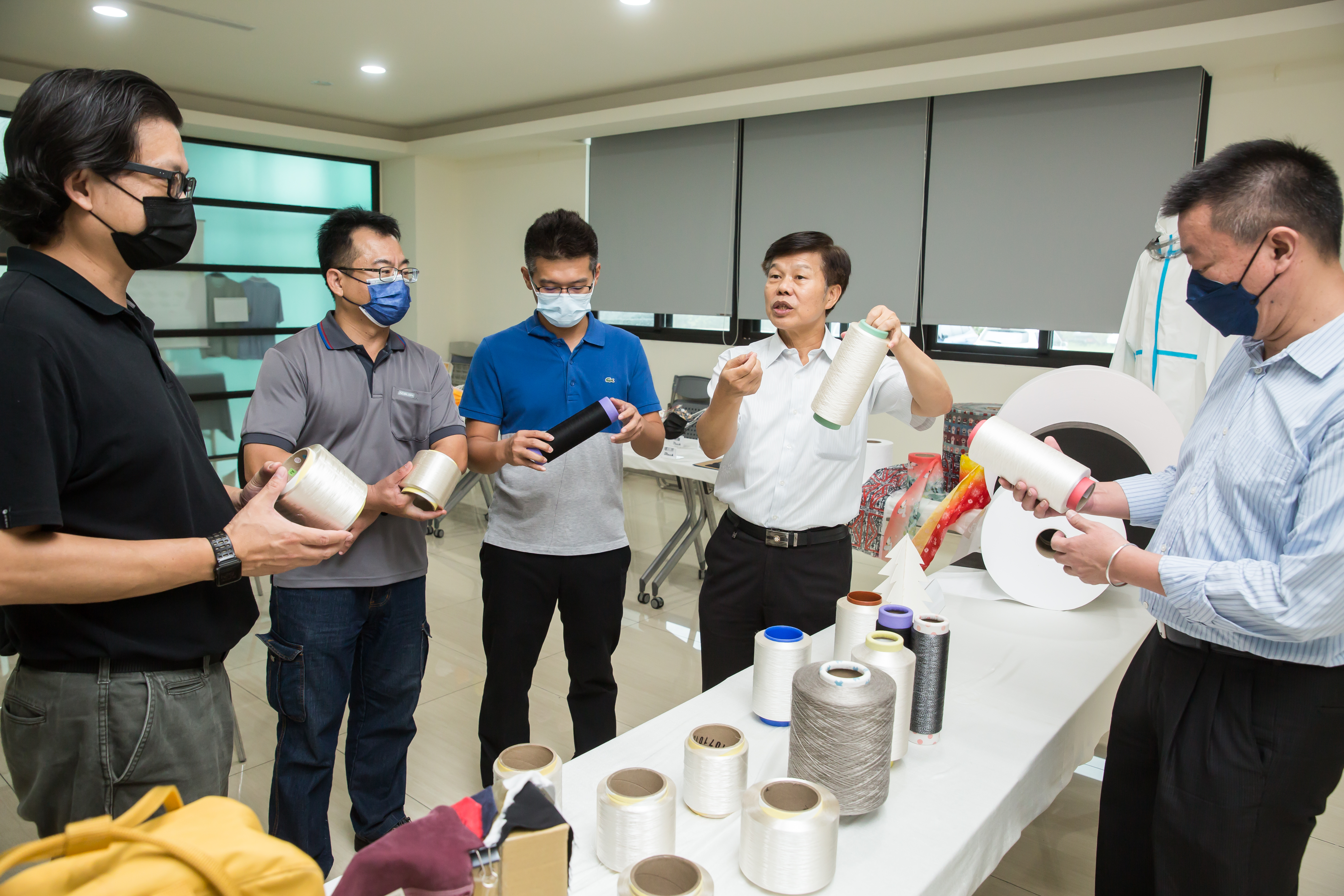 周文東（右2）帶領公司挺過風風雨雨，如今以產品多樣化往高端路線邁進。