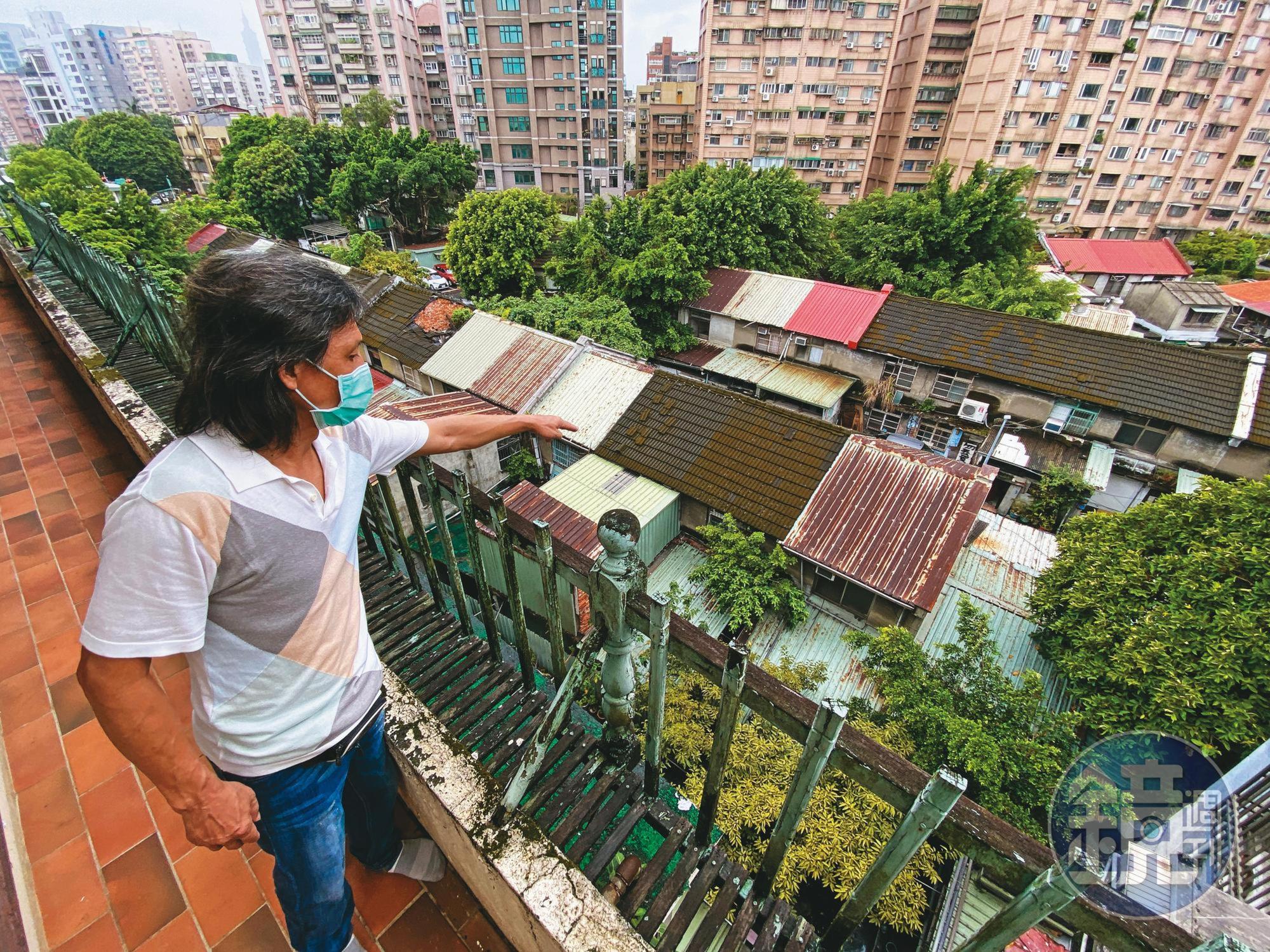 王姓住戶站在屋齡49年的老公寓,指著眼前即將都更的忠誠新村,希望北市府能將他們納入都更範圍。