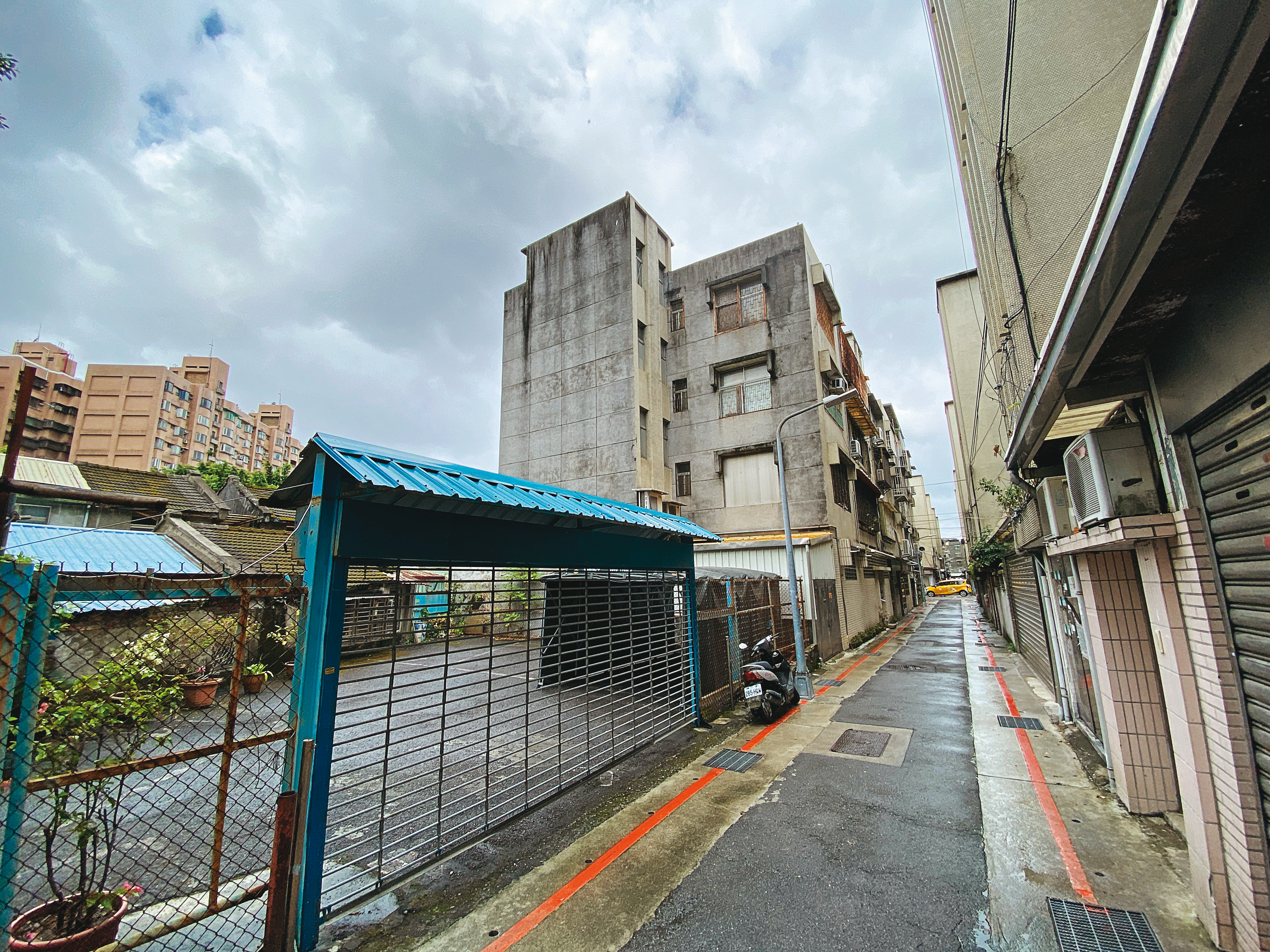 原本是停車場的畸零地被巧洋建設買走後,右方的16戶公寓基地因未滿300坪,難以自辦都更。