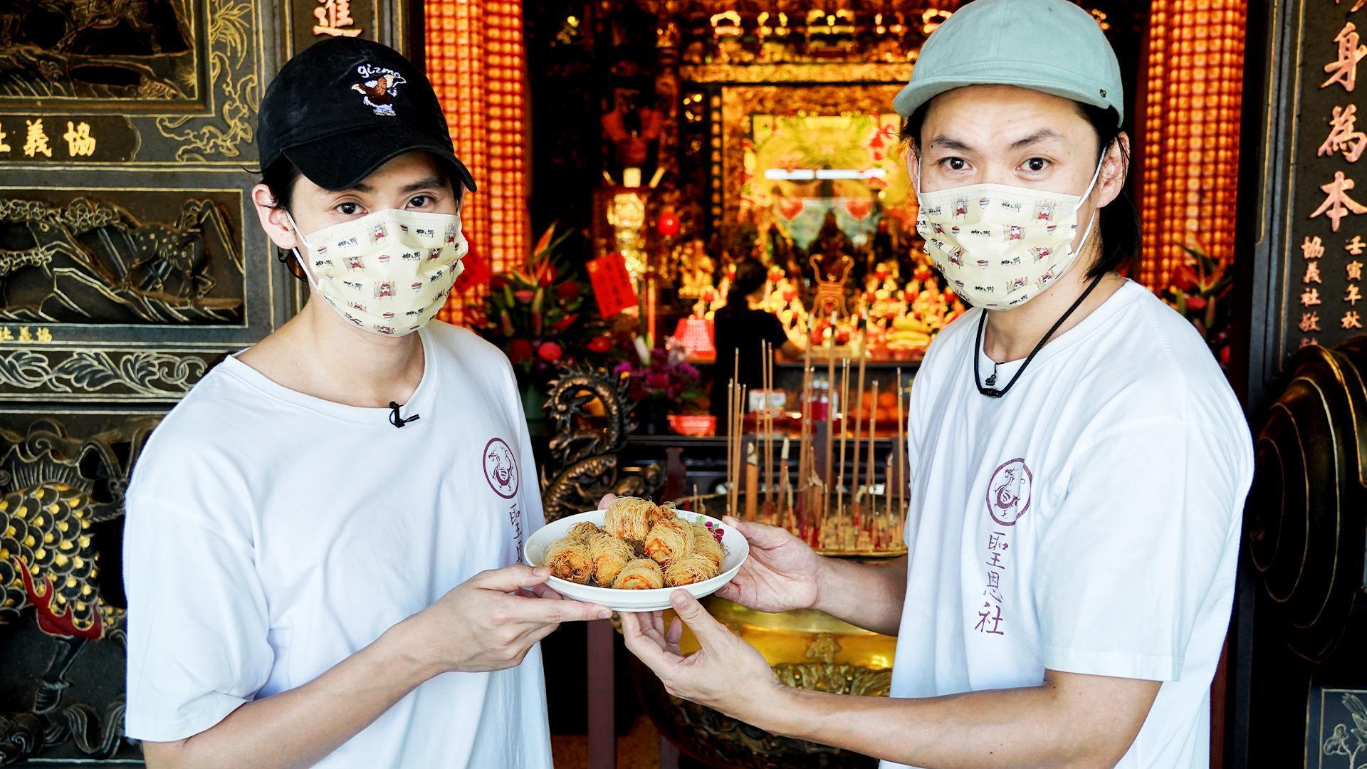 李玉璽(左)與黃鐙輝(右)將親自製作的陀螺炸雞帶到大溪普濟堂,感謝關聖帝君保庇。(東森電視、映畫提供)