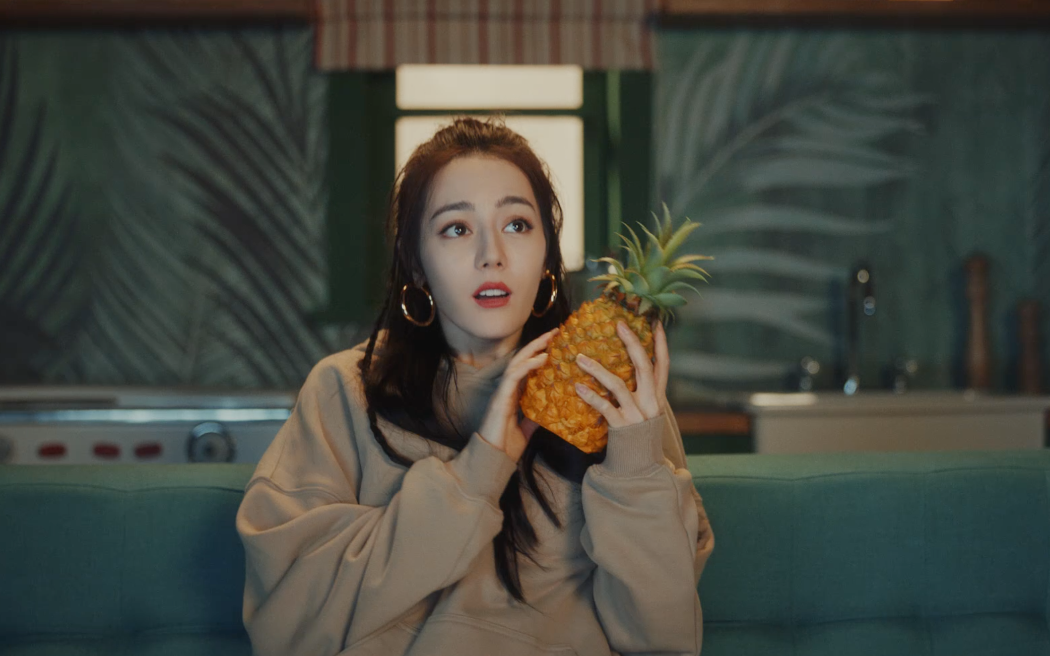 女星迪麗熱巴新任WeTV全球代言人，在宣傳影片裡抱鳳梨的表情超可愛。（截圖自影片）