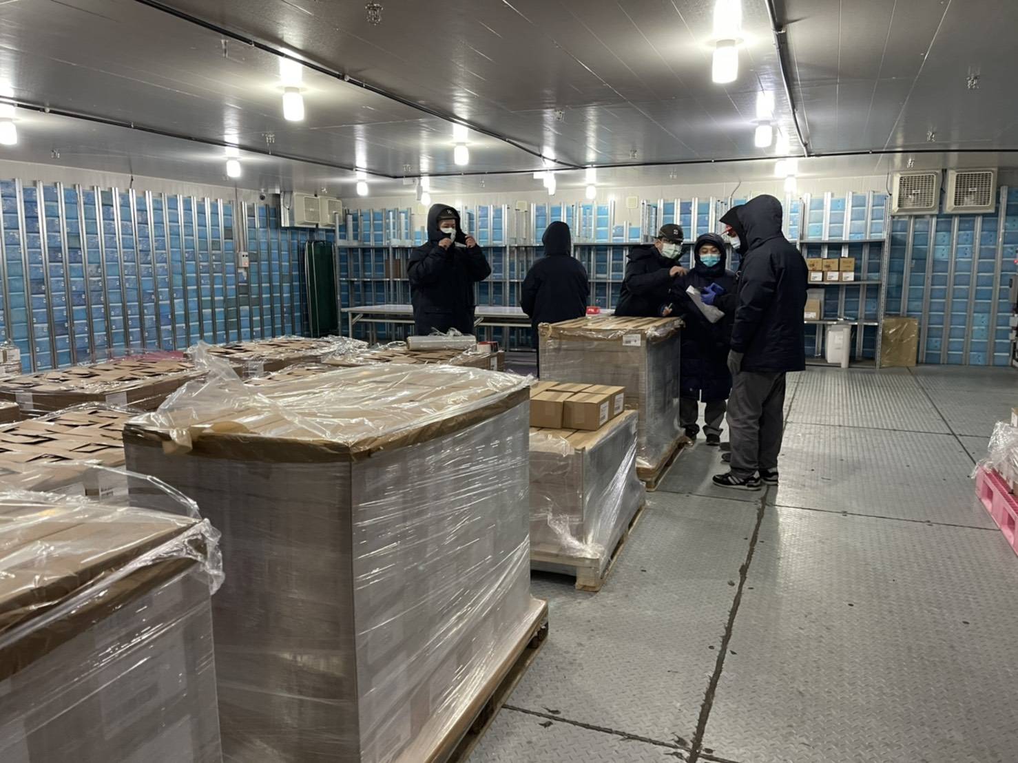 COVID-19疫苗送抵裕利醫藥物流中心後，食藥署人員會進行抽驗檢驗、封緘。（裕利醫藥提供）