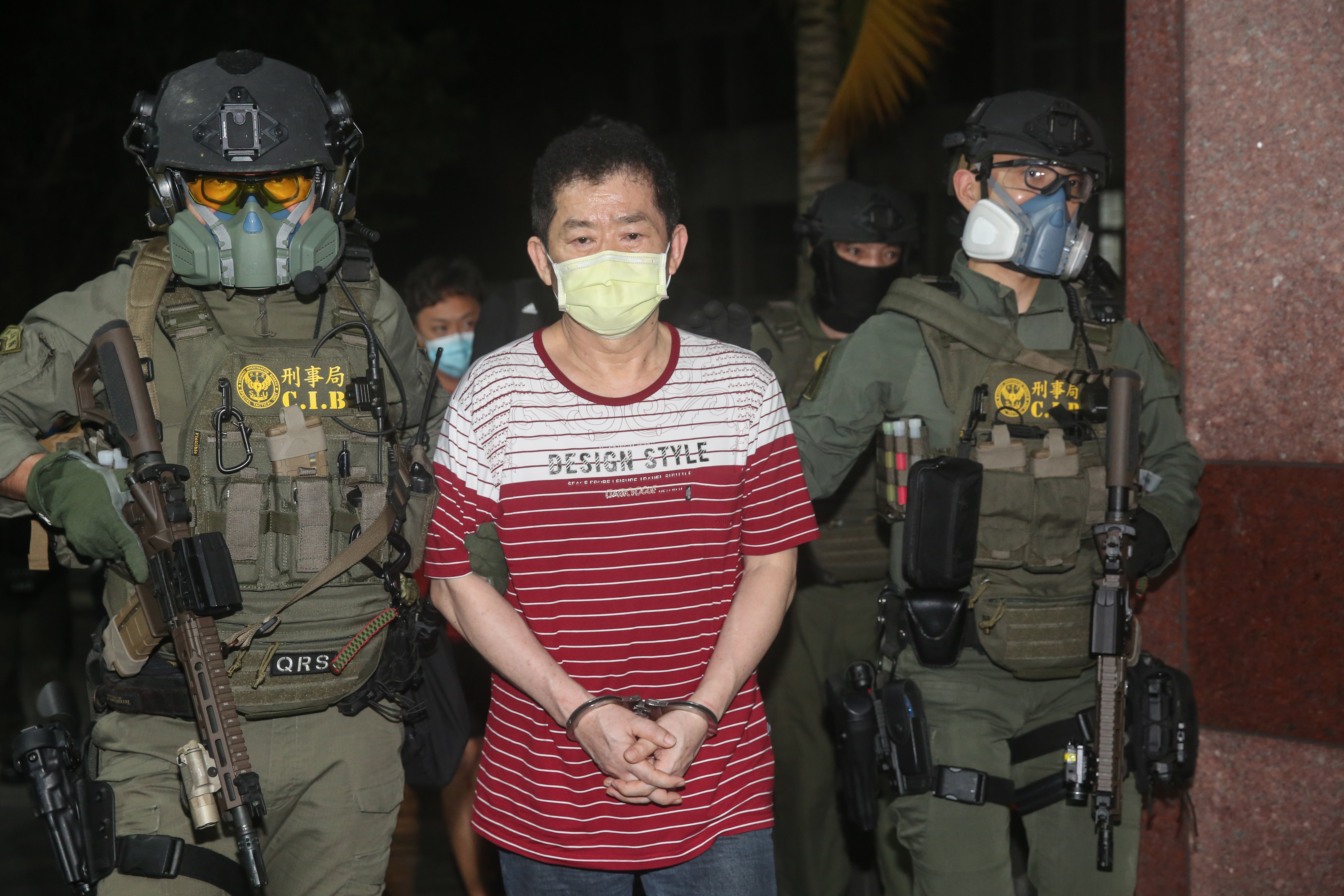 涉及多起刑案的「美鷹會」精神領袖王鑫（中），今日凌晨由刑事局特勤隊重裝押解到案。