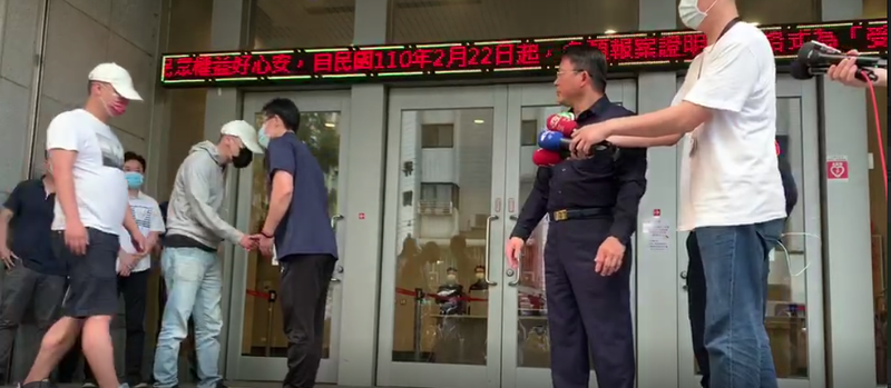 松山分局教官與黑衣人起衝突後,遭黑衣人闖入派出所鬧事,事後雙方竟大動作握手言和,引發爭議。(松山分局提供)