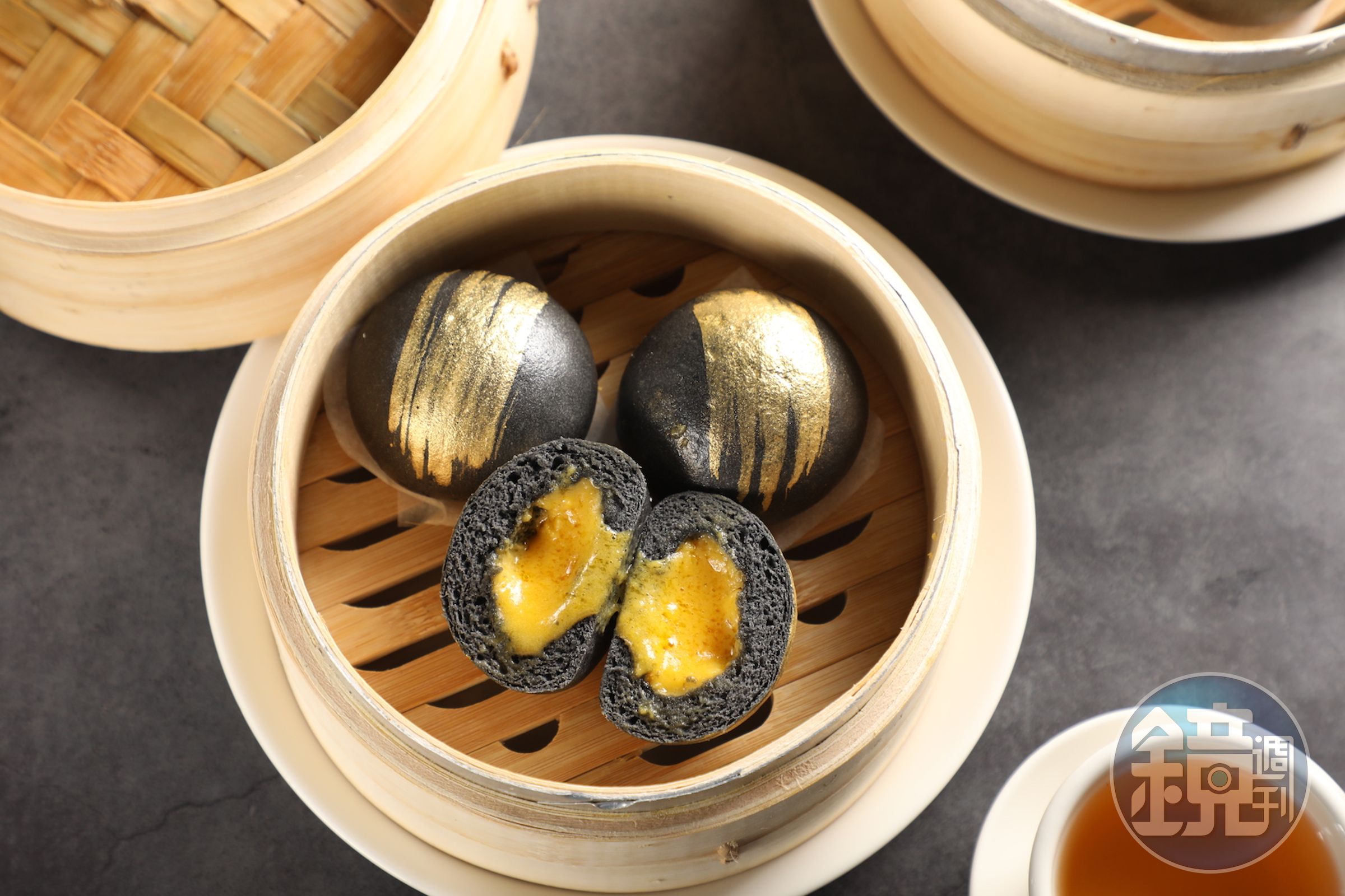 「金箔流沙包」竹炭麵皮刷上食用金粉，呼應內餡濃郁的金沙餡。（150元／份）