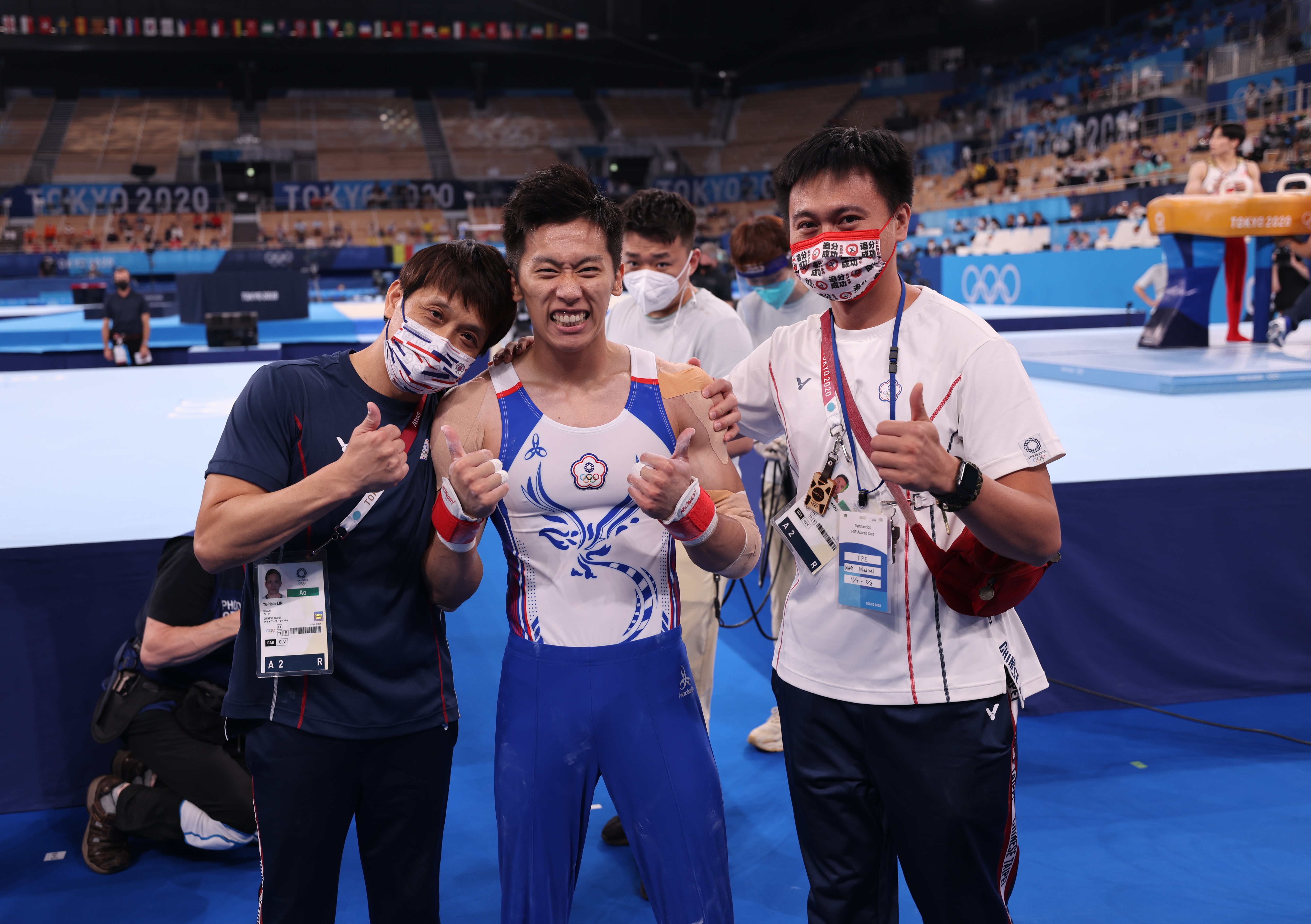 李智凱(中)賽後和教練林育信(左)合影,在奧運站上頒獎牌,是師徒多年來的夢想。(體育署提供)