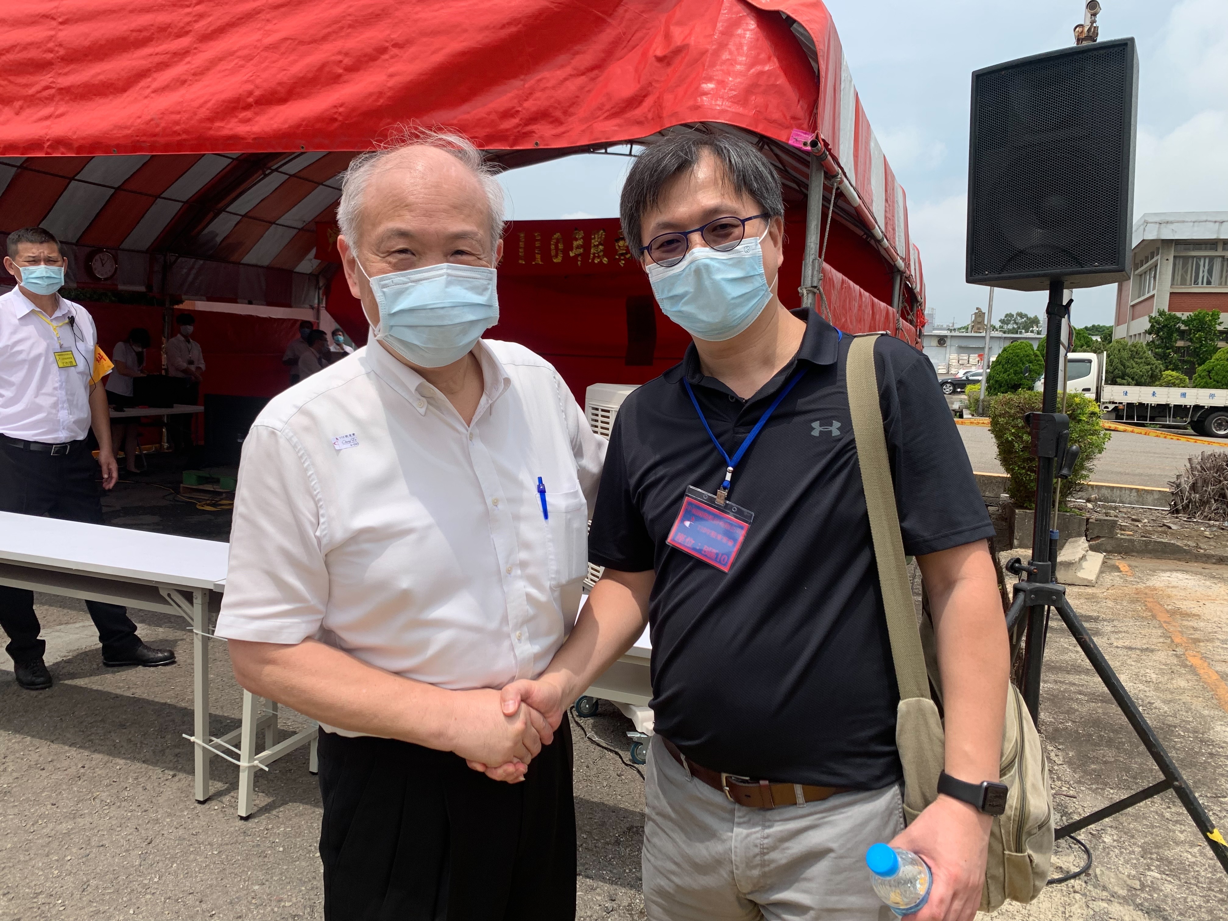 老字號紡織廠中福今日召開股東會，會後董事長黃立中也和市場派代表黃致鋐握手致意。