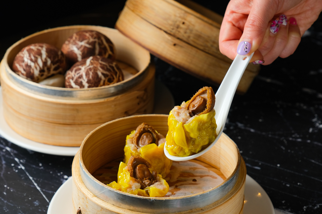 「鮑魚燒賣皇」（前，240元／份）鮮味濃郁，口感彈實；擬花菇造型的「珍菇流沙包」（後，150元／份），麵皮蓬軟、內餡濃郁。