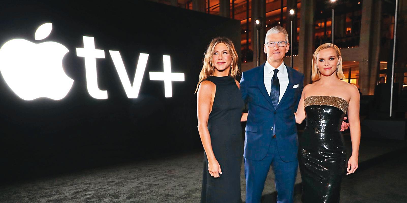 蘋果公司2年前加入串流戰局推出Apple TV +，首波原創節目主打珍妮佛安妮斯頓（左）和瑞絲薇斯朋（右）主演的《晨間直播秀》，中為蘋果公司執行長提姆庫克。（翻攝自appletvplus.com）