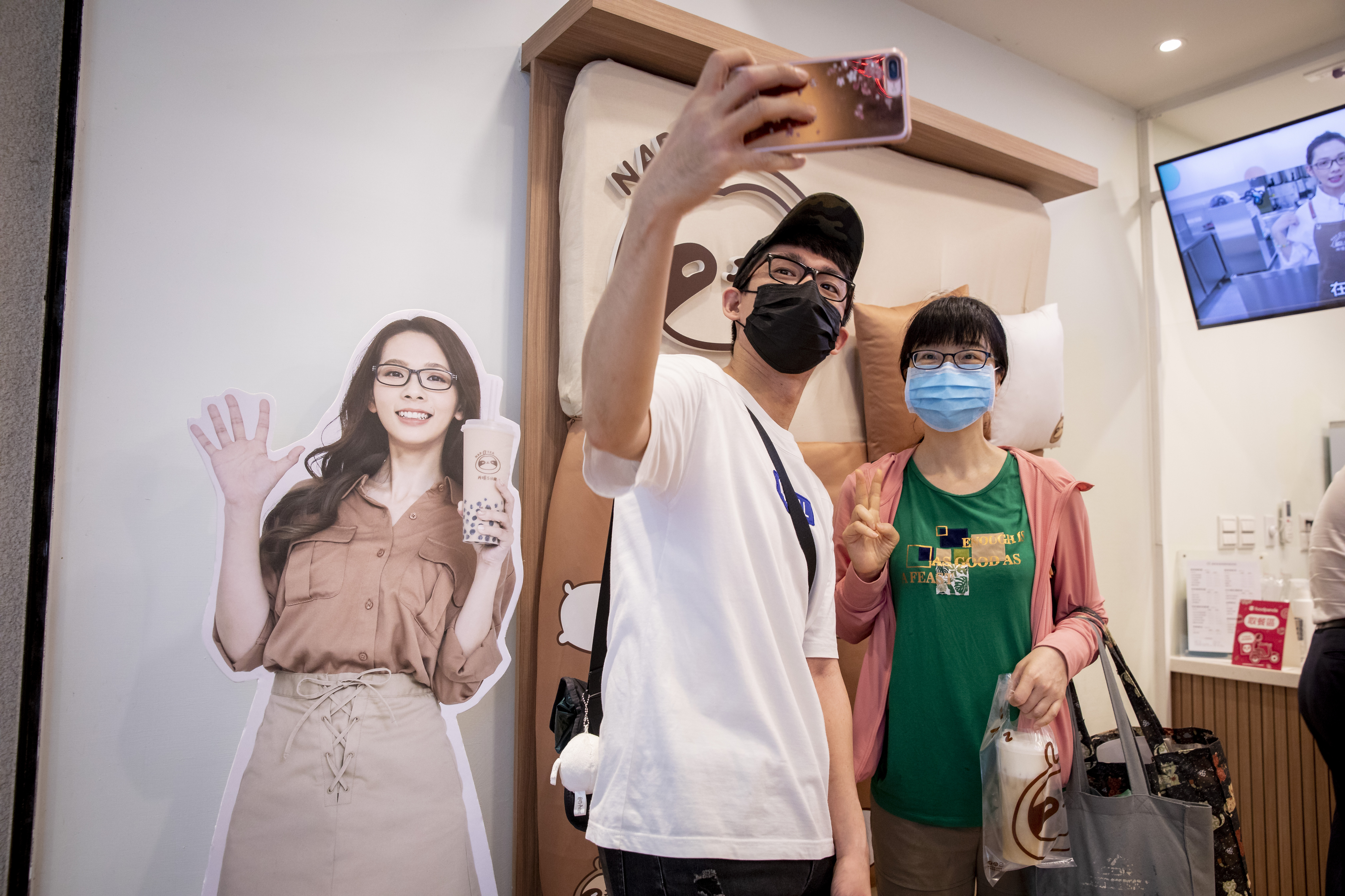 微解封後，阿滴（右二）帶我們到滴妹的飲料店拍照，即使戴著口罩也被民眾認出，詢問能否合照。已經好轉的他，熱情地拿著粉絲的手機自拍。