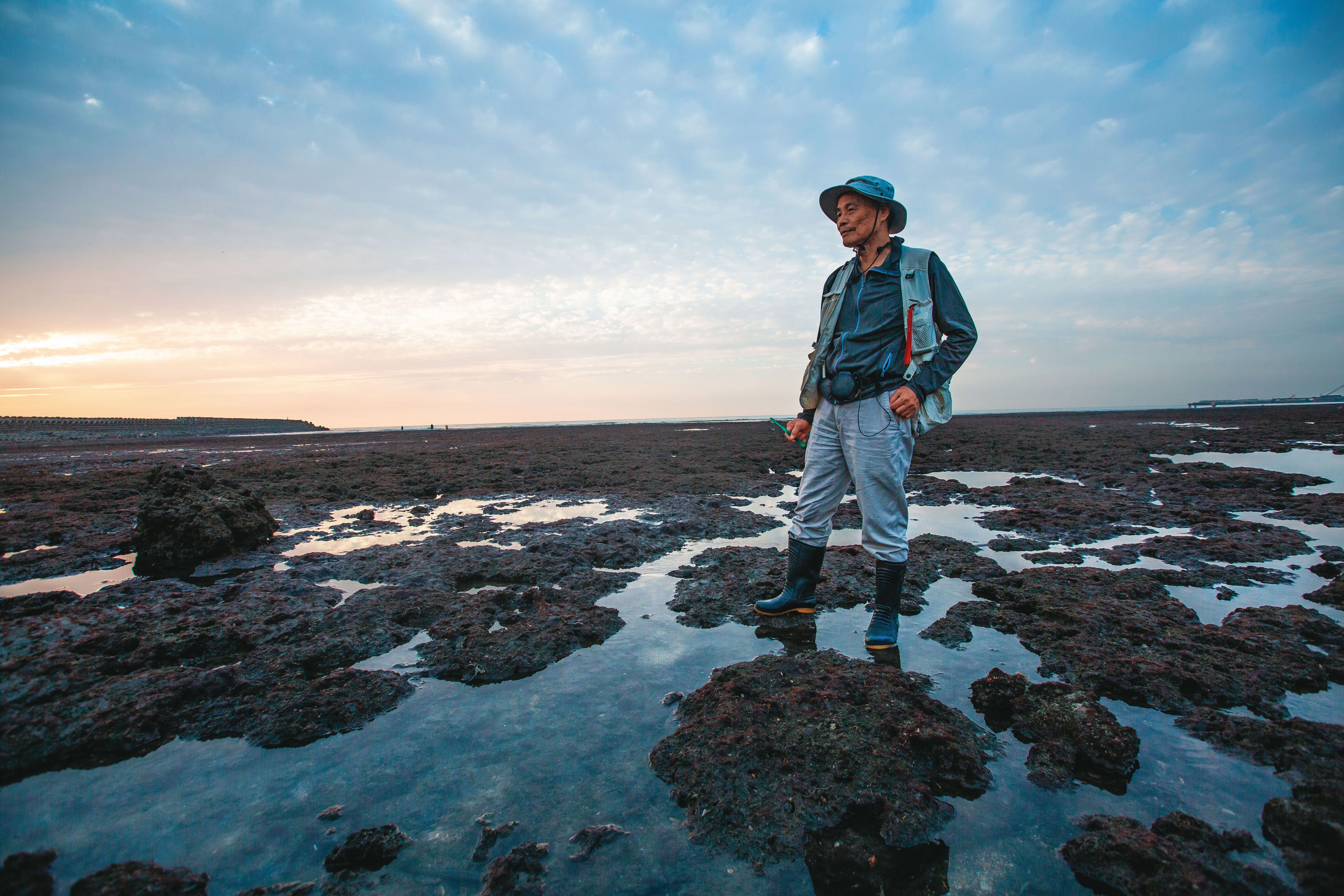 潘忠政的藻礁夜觀行程，必會穿著雨鞋，以便在崎嶇的礁石間穿梭。他為保育海岸奔走超過30年，發起公投原只是要抗議政府程序不公，卻意外在政界及環團間捲起千堆雪。