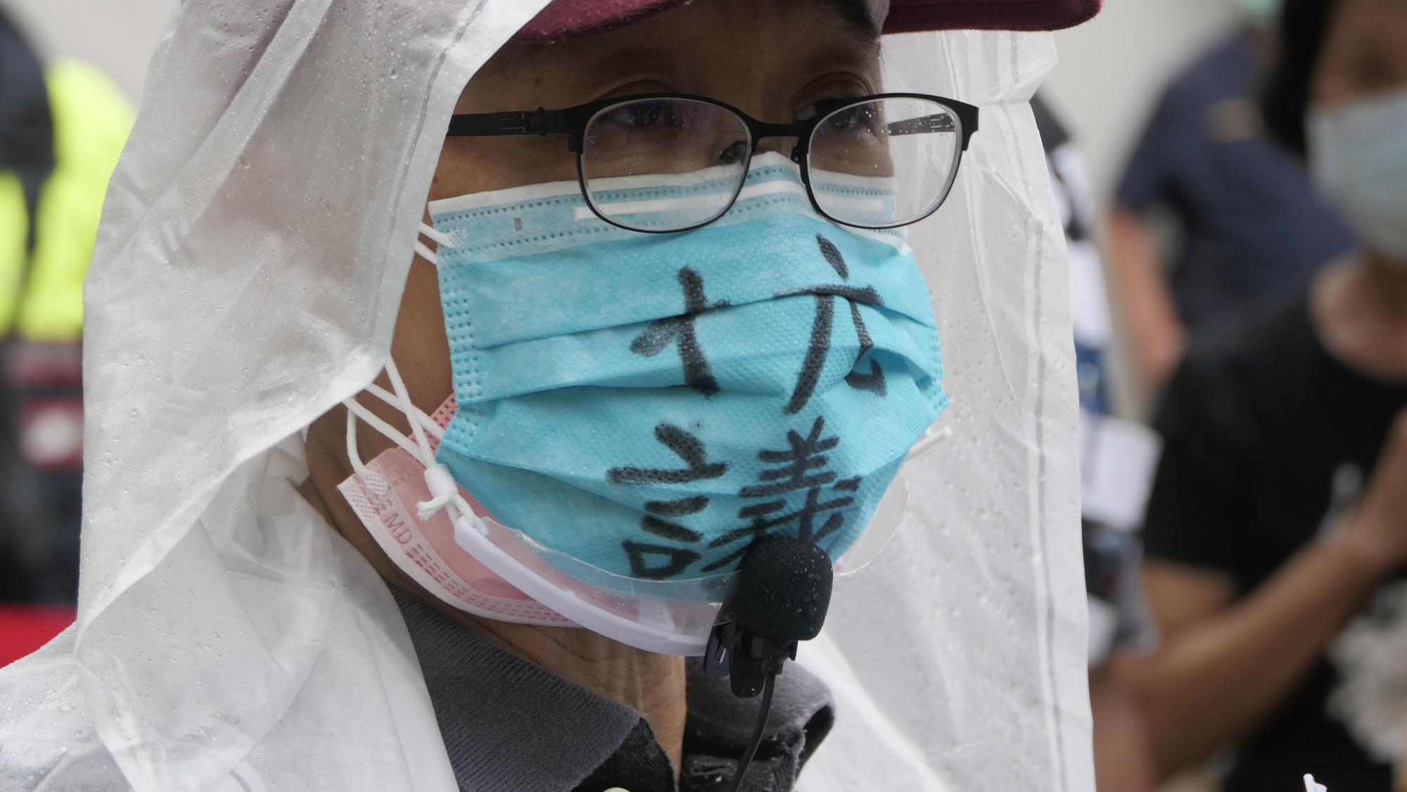 拆遷戶戴上寫著「抗議」的口罩，表達內心的不滿。（讀者提供）