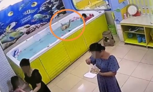 女童在泳池戲水時，不慎倒栽在水中，但母親和阿姨在一旁毫無察覺。（翻攝自微博）