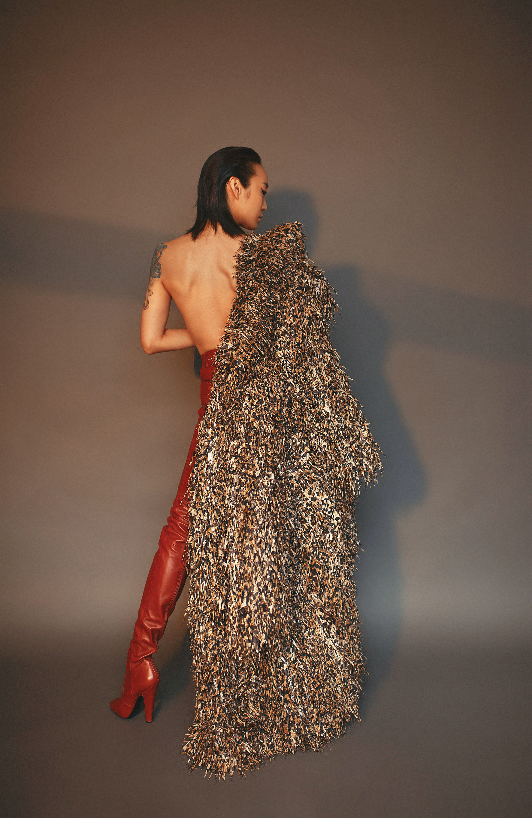 環保布料造型大衣 價格店洽 by BALENCIAGA；橘紅色皮褲靴  價格店洽 by SANIT LAURENT。