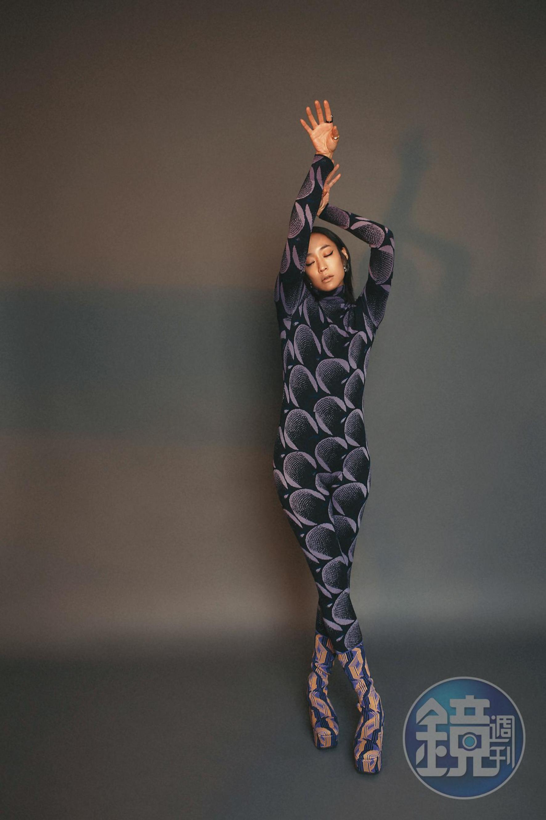幾何連身服 NT$82,000 by PRADA；幾何緹花襪靴 NT$50,000 by PRADA；五件組鍍金純銀戒指 NT$29,700 by BOTTEGA VENETA；Millenia穿孔耳環 NT$6,490 by SWAROVSKI。