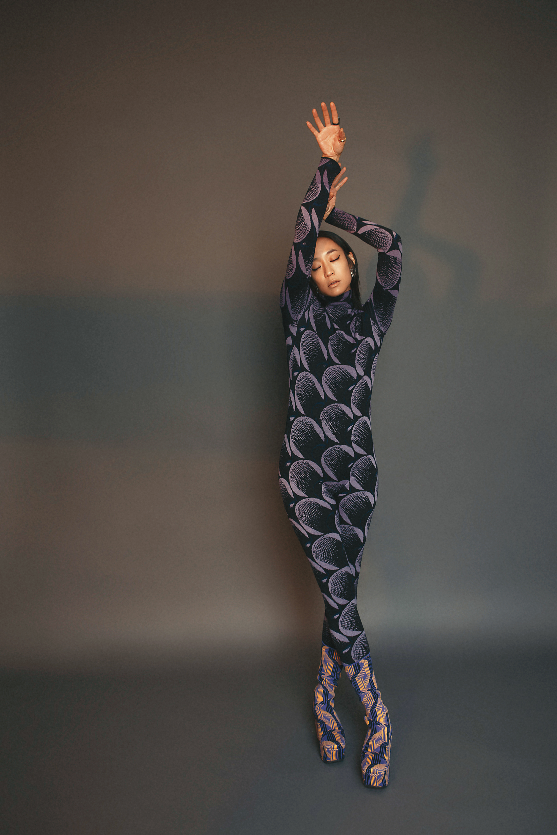 幾何連身服 NT$82,000 by PRADA；幾何緹花襪靴 NT$50,000 by PRADA；五件組鍍金純銀戒指 NT$29,700 by BOTTEGA VENETA；Millenia穿孔耳環 NT$6,490 by SWAROVSKI。