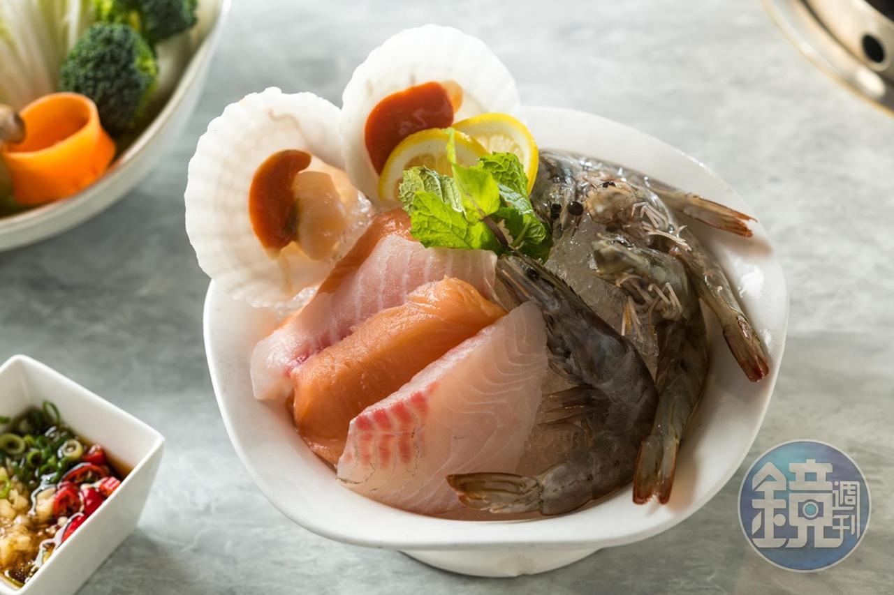 麻辣鍋套餐的綜合海鮮盤裡有鮭魚、鯛魚、白蝦和扇貝。 