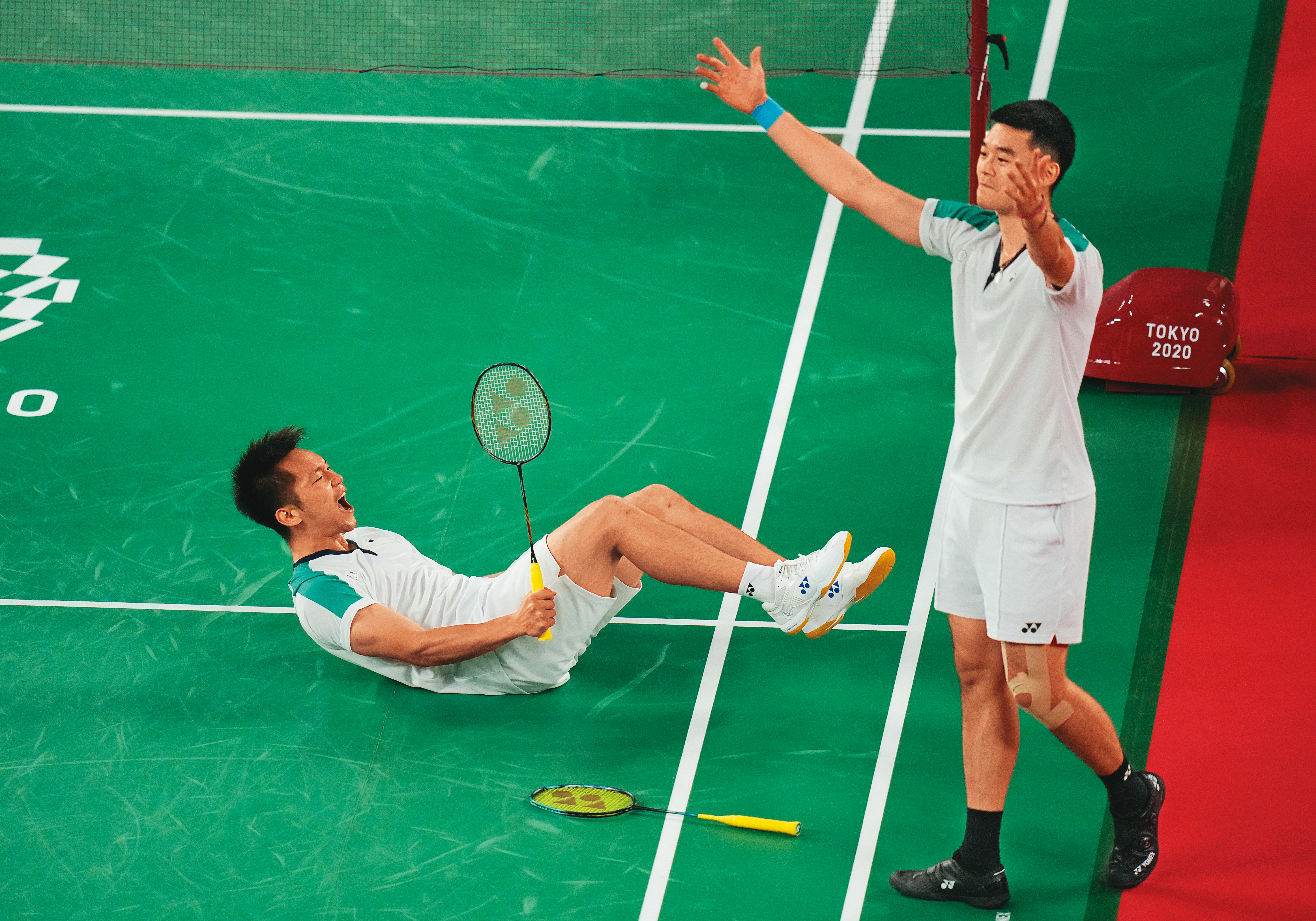 決勝球經電腦判定落在線上，確定贏下金牌時，李洋（左）振奮大吼，而王齊麟（右）揚起雙臂回應觀眾席上戰友的歡呼。（達志影像）