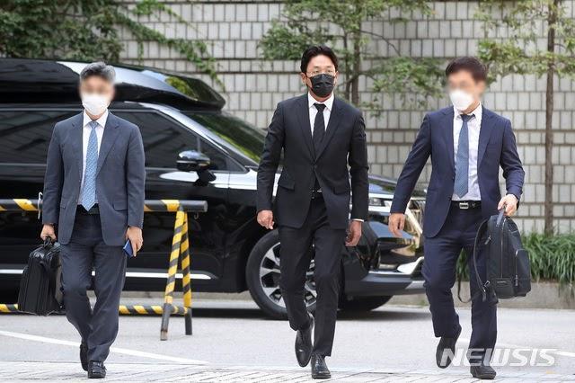 河正宇(中)今在律師隨同下現身首爾中央地方法院出庭。(翻攝自NEWSIS)