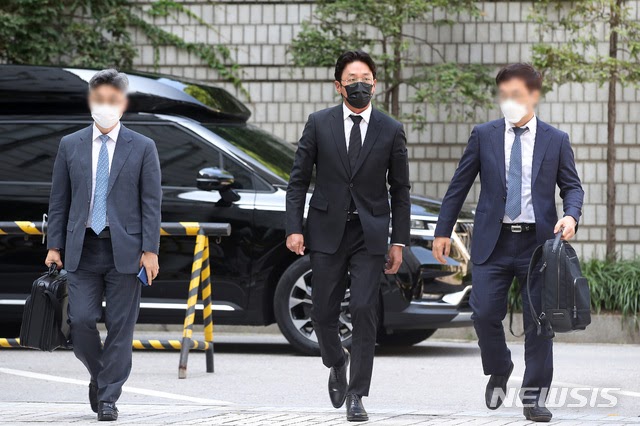 河正宇（中）今在律師隨同下現身首爾中央地方法院出庭。（翻攝自NEWSIS）