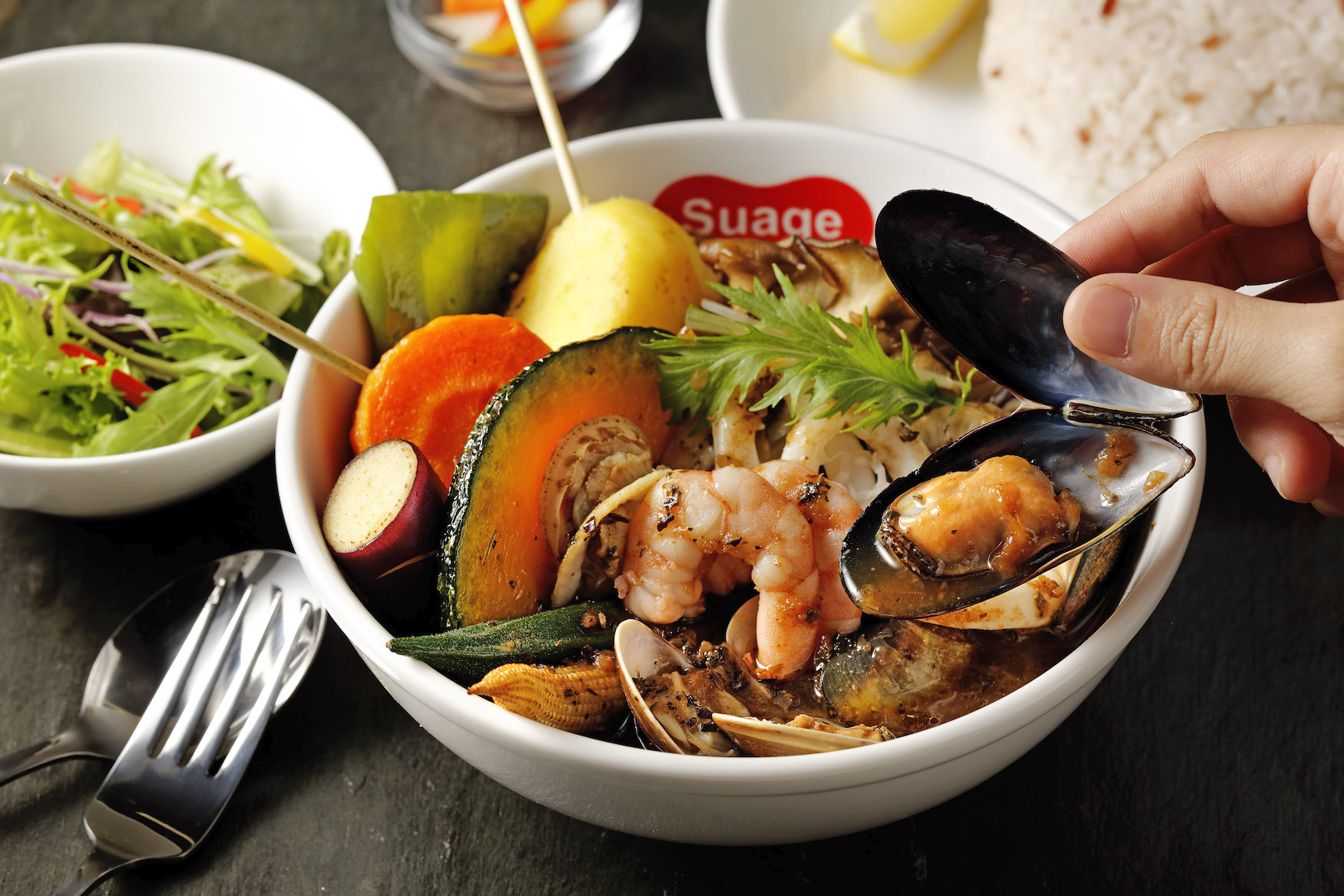 台灣限定的「綜合海鮮湯咖哩」以帆立貝、大蝦仁、蛤蜊、花枝、淡菜海鮮料呈現豐富的海鮮風味，搭配墨魚湯頭滋味更濃郁。（420元／份，Suage提供）