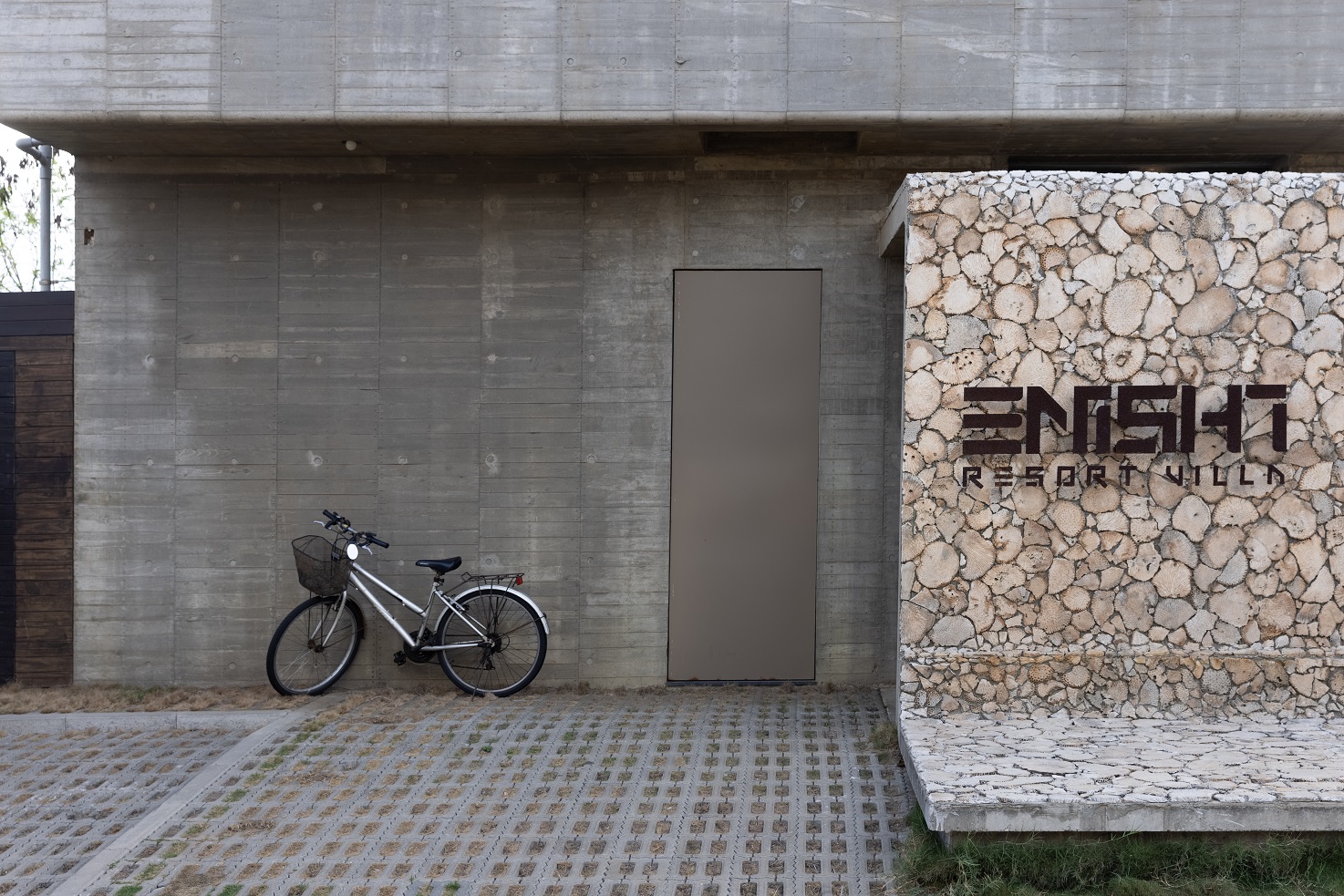 水泥色外觀，以及幾乎看不出招牌的「ENISHIRESORT VILLA緣民宿」。