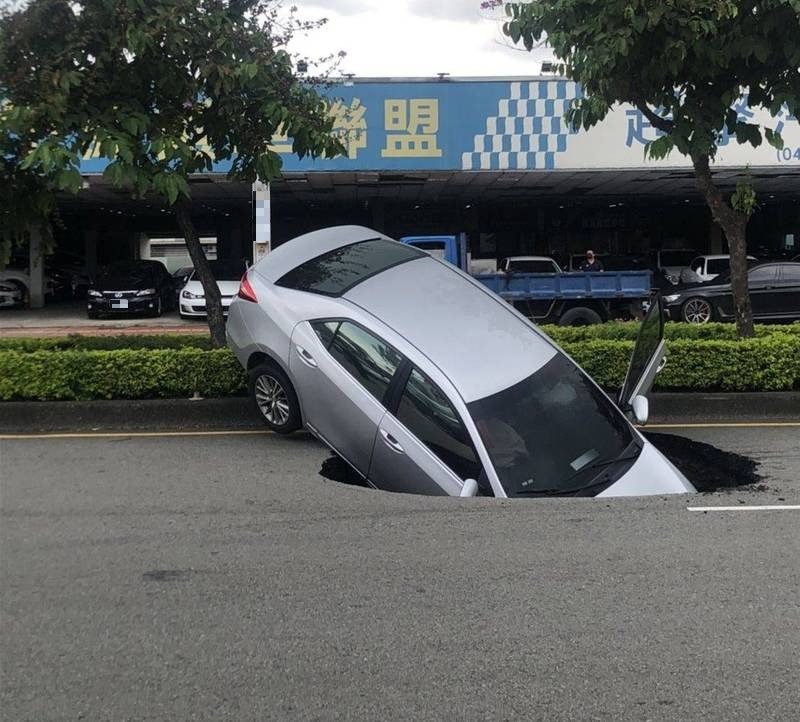 連日豪雨出現天坑,一名林姓婦人連人帶車栽進坑裡。(市府提供)