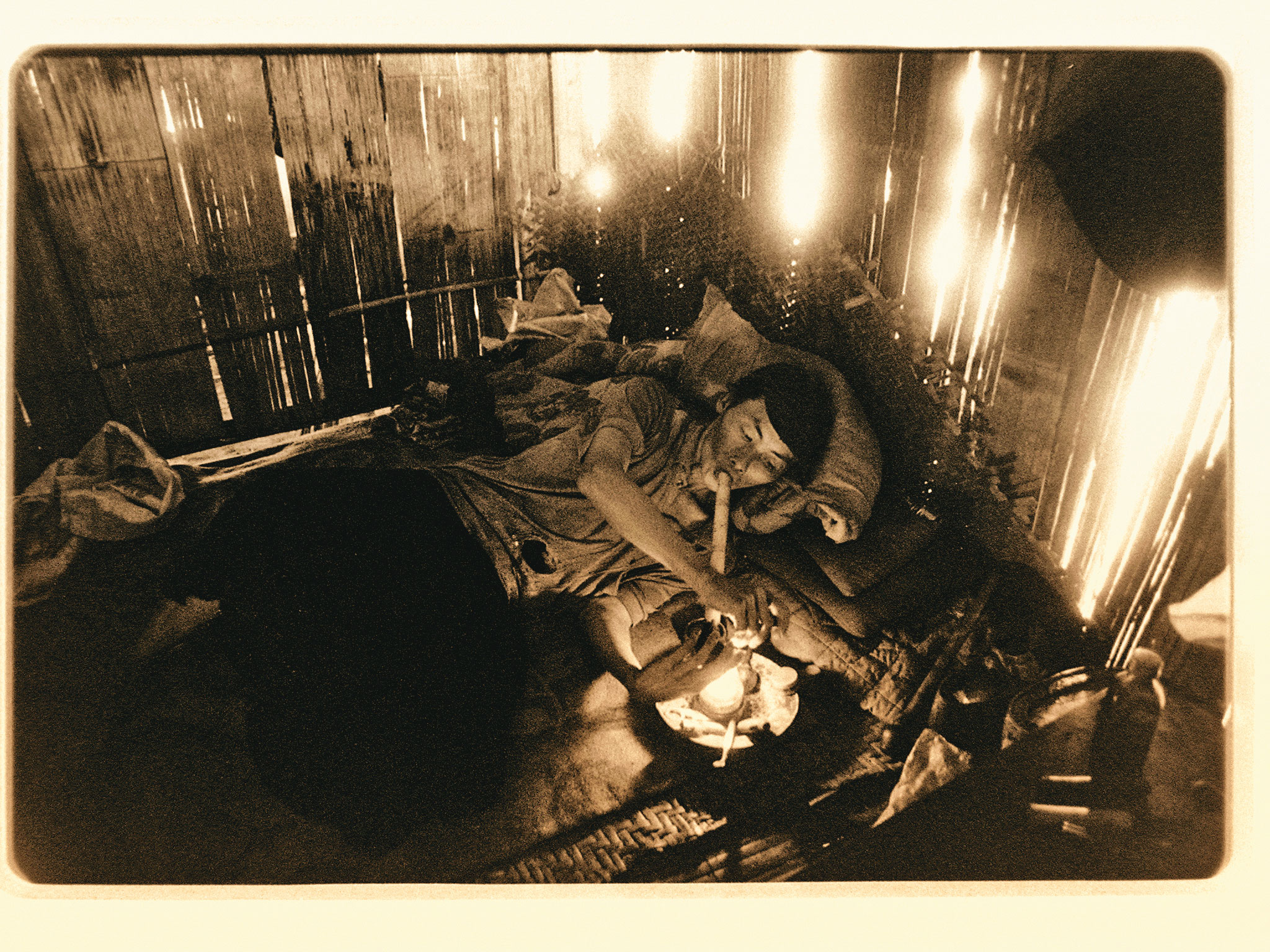 海洛因是由鴉片原料提煉的精神抑制劑，近年在寮國郊區仍可見吸食鴉片的人。