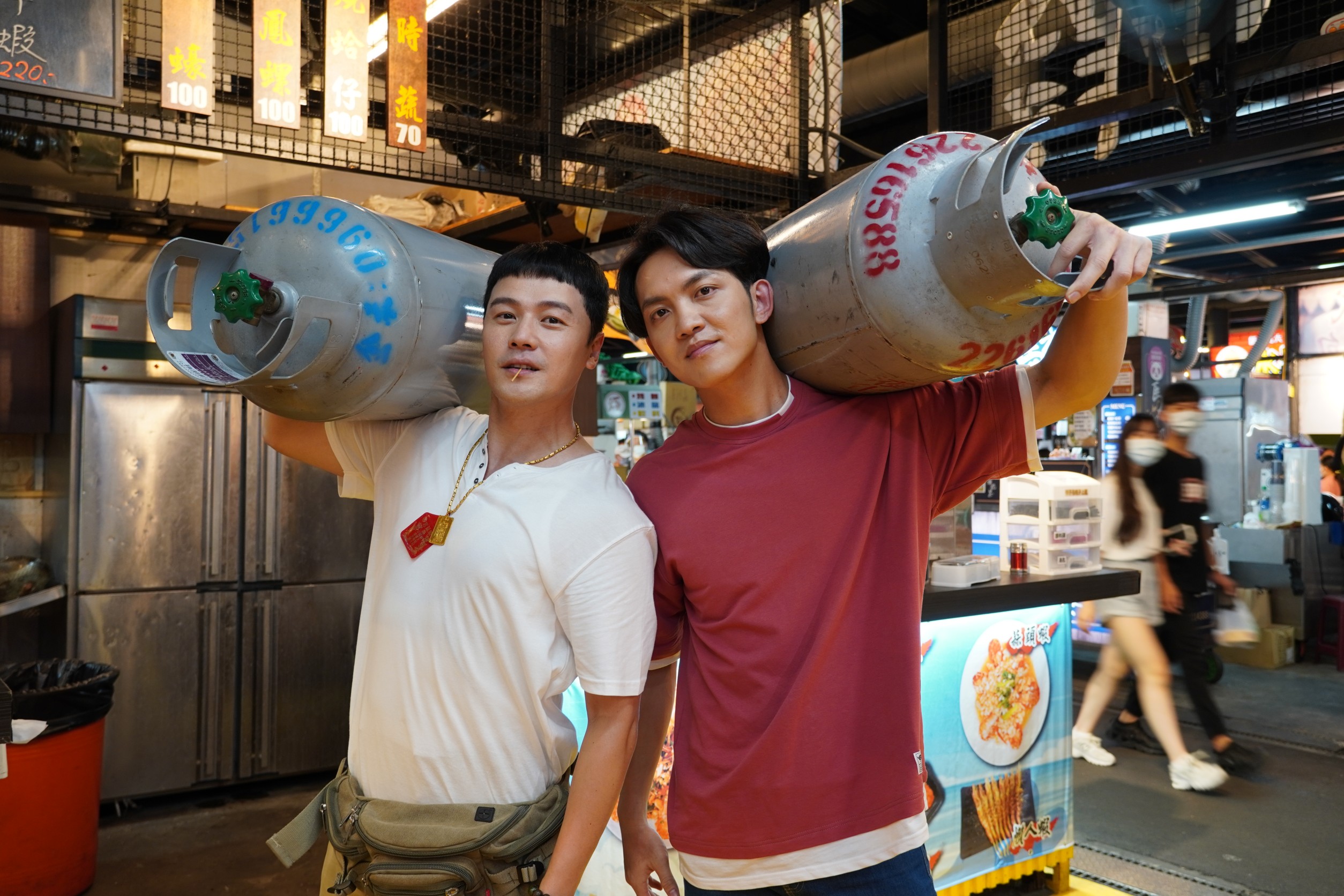 黃文星和郭忠祐扛起瓦斯罐。（民視提供）