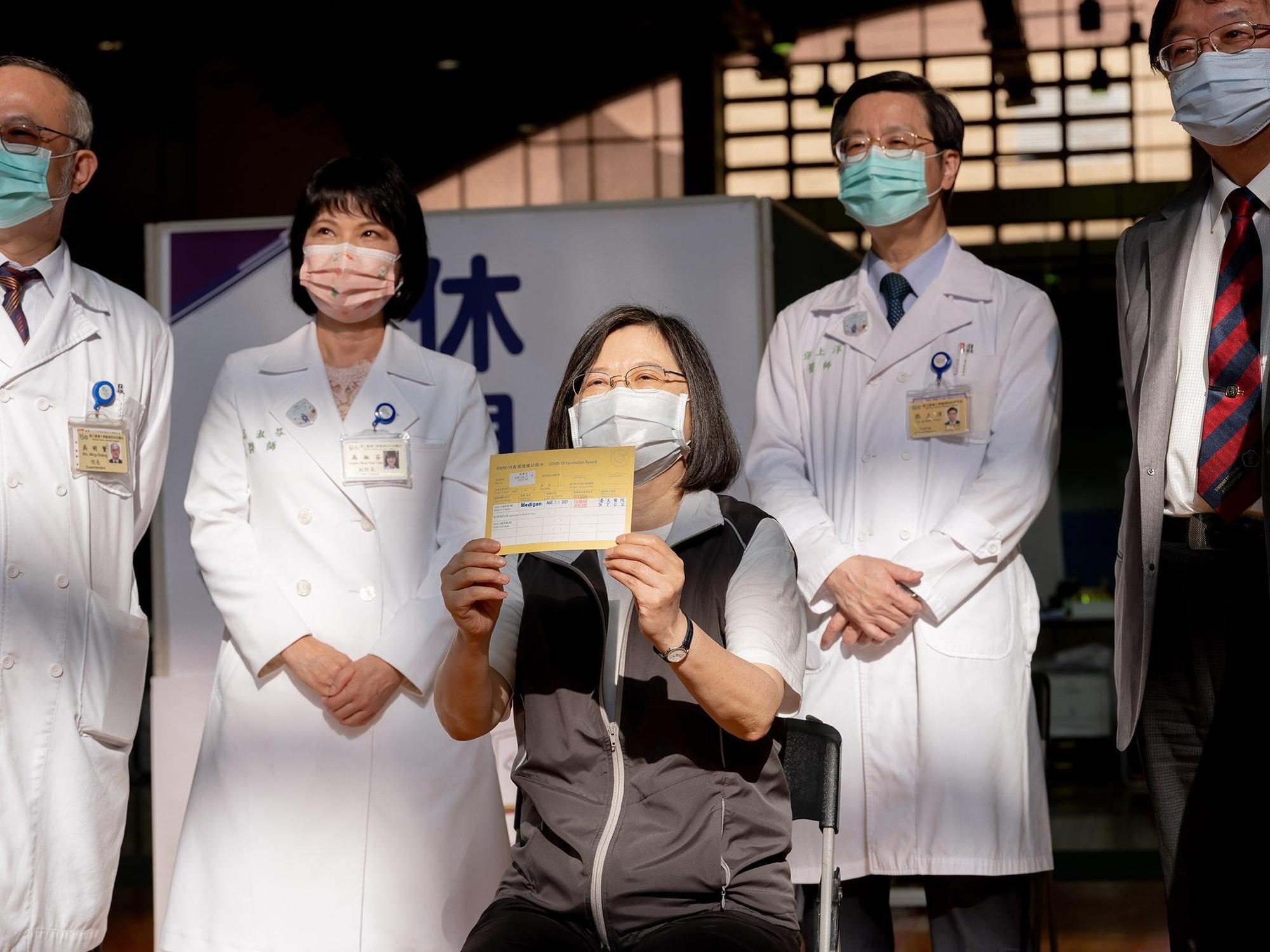 總統蔡英文(中)今日接種國產疫苗高端,開心秀出小黃卡。(翻攝自蔡英文臉書)