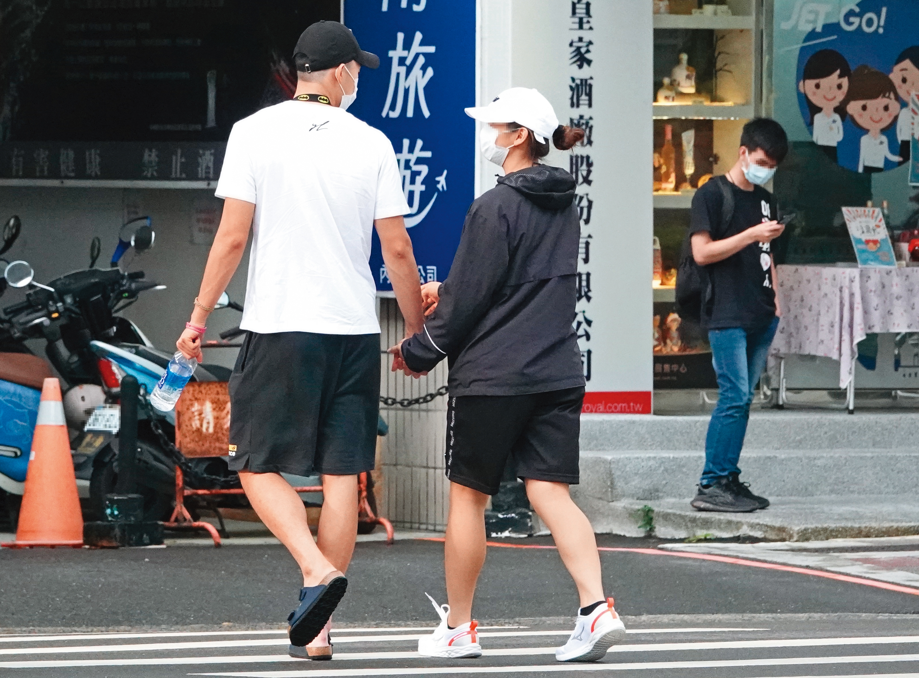 16：59，過馬路時，王齊麟緊緊牽住女友的手，可見小別勝新婚。