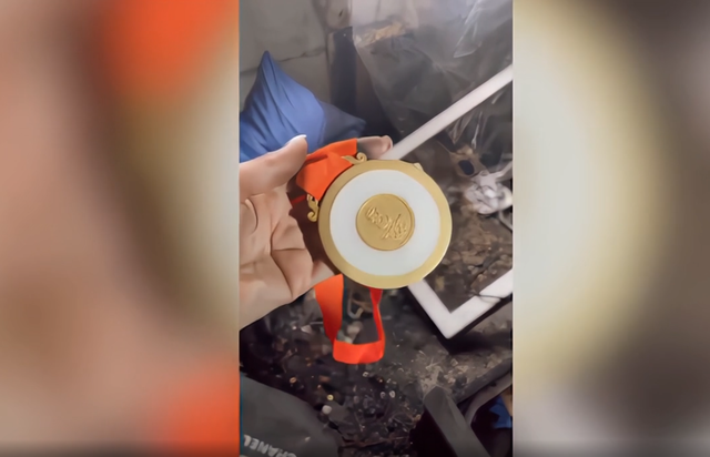 中國媒體報導時,還特別提到之前有俄羅斯選手家中火災,但她在北京奧運拿的金鑲玉金牌毫髮無損,連帶子都是完整的。(翻攝每經網www.nbd.com.c)